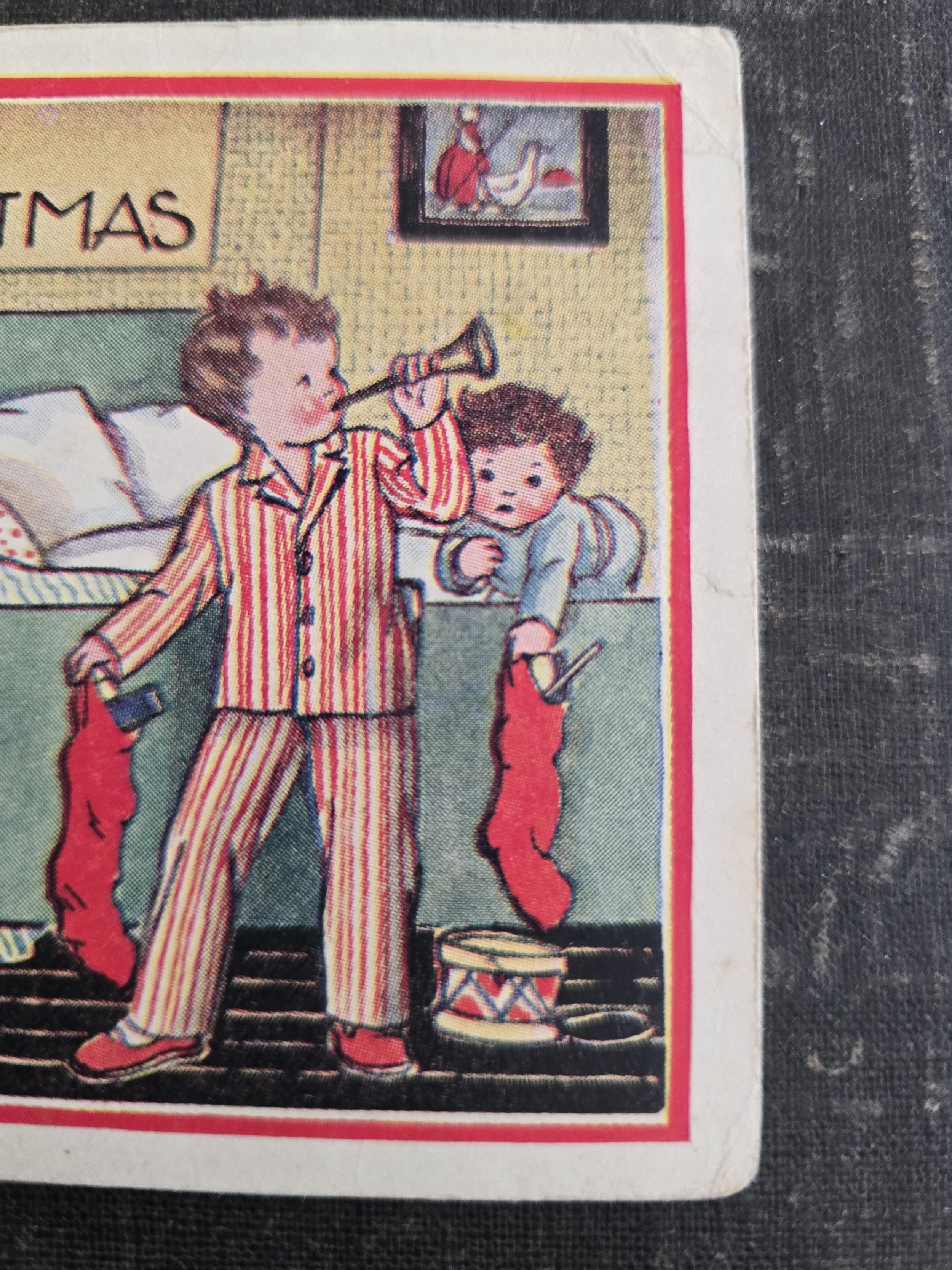 Close-up of vintage Christmas illustration showing children gathered around a bed with festive stockings.