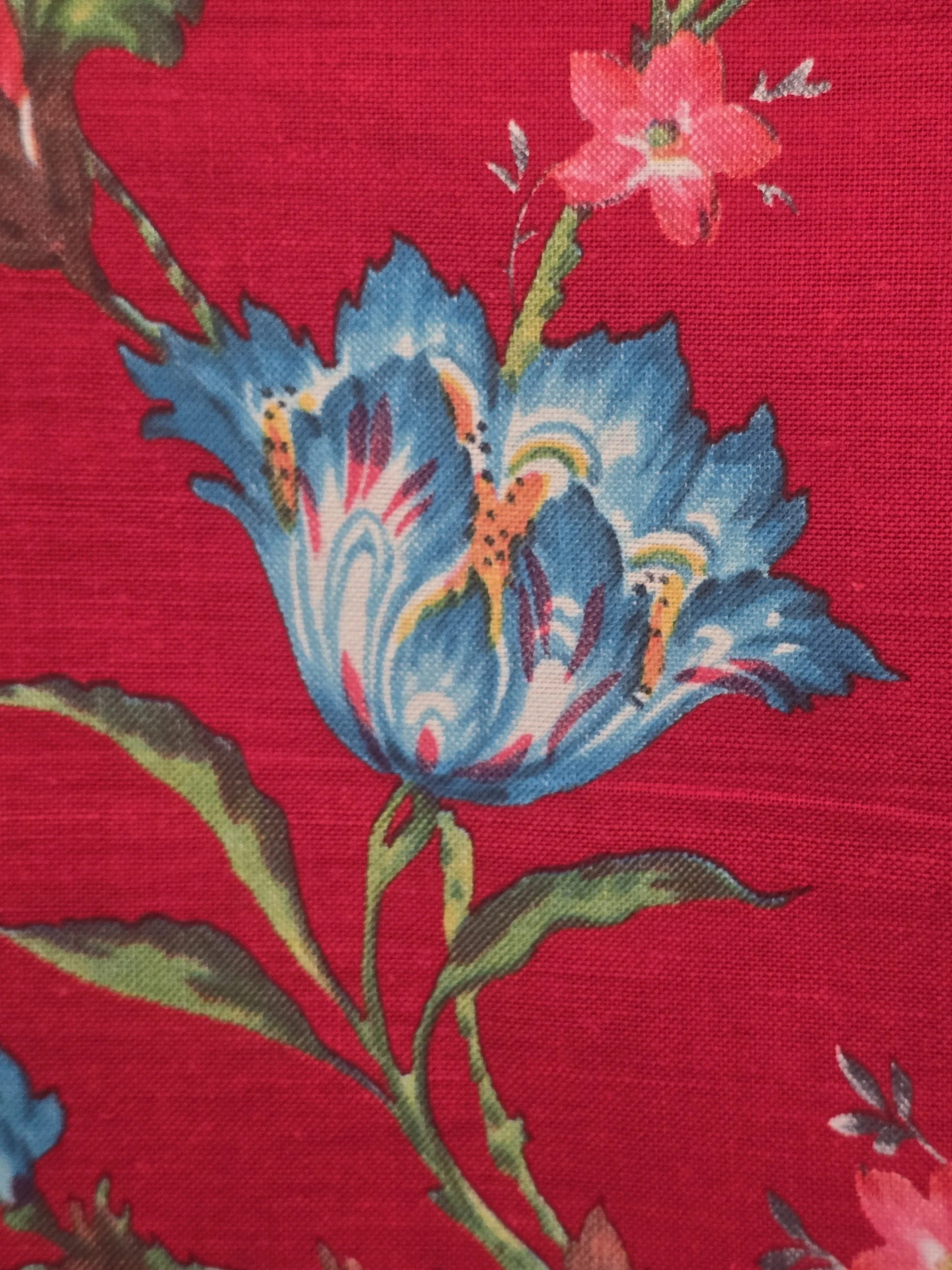 Selvedge of unused vintage furnishing fabric with printed grand teint meuble wording beside the red floral design.