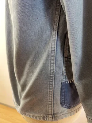 Back view of vintage French chore jacket showing fading