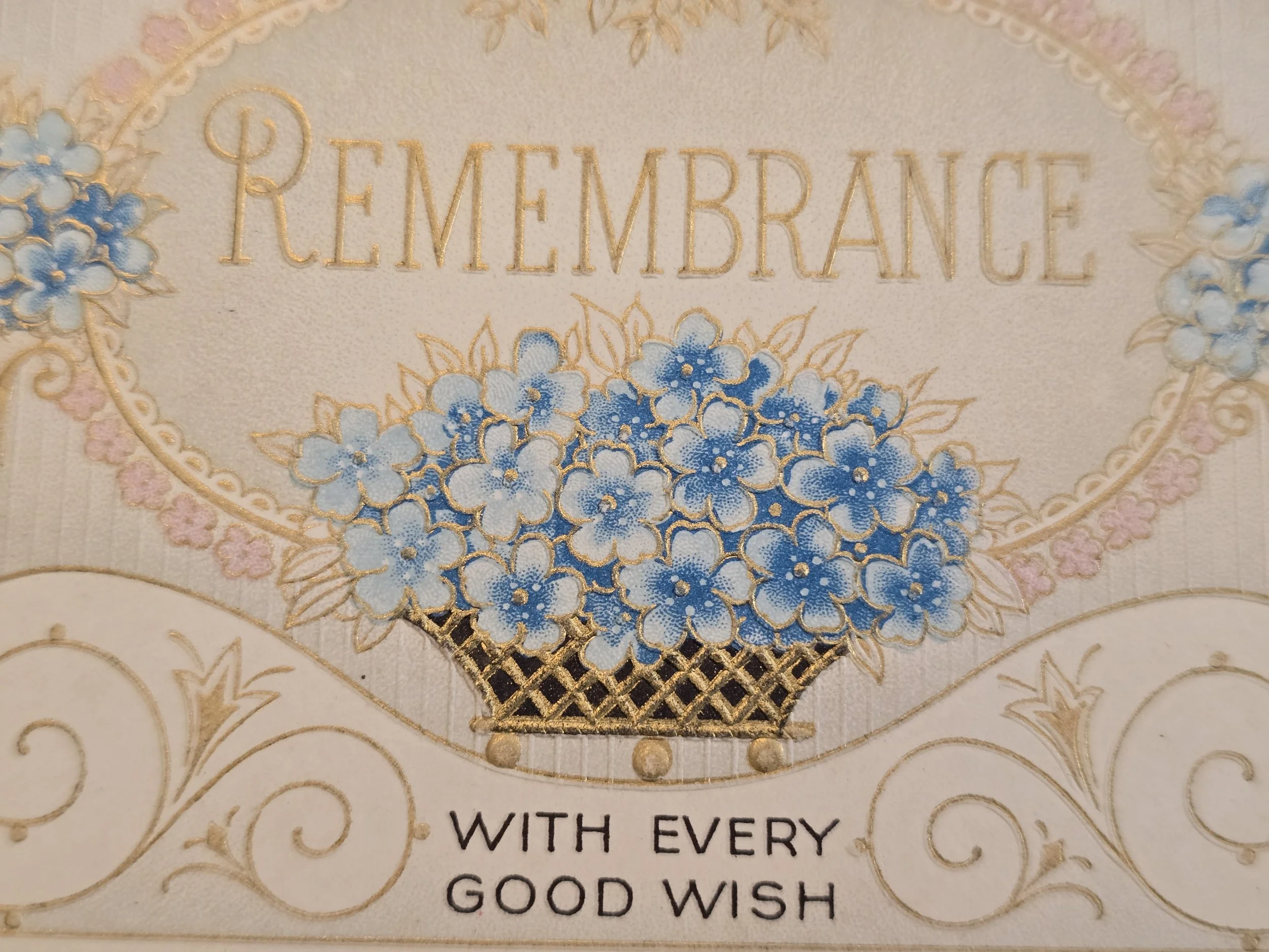 Close-up of the gold decorative lettering and blue floral basket illustration on a 1935 Christmas card.