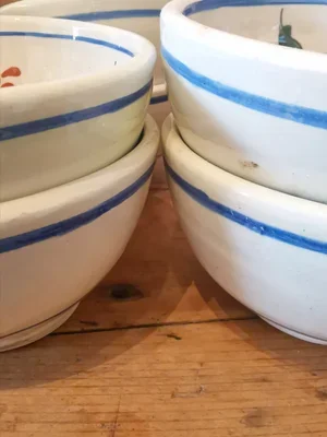 Stack of six vintage French hand painted floral bowls with blue rim, rustic country pottery.