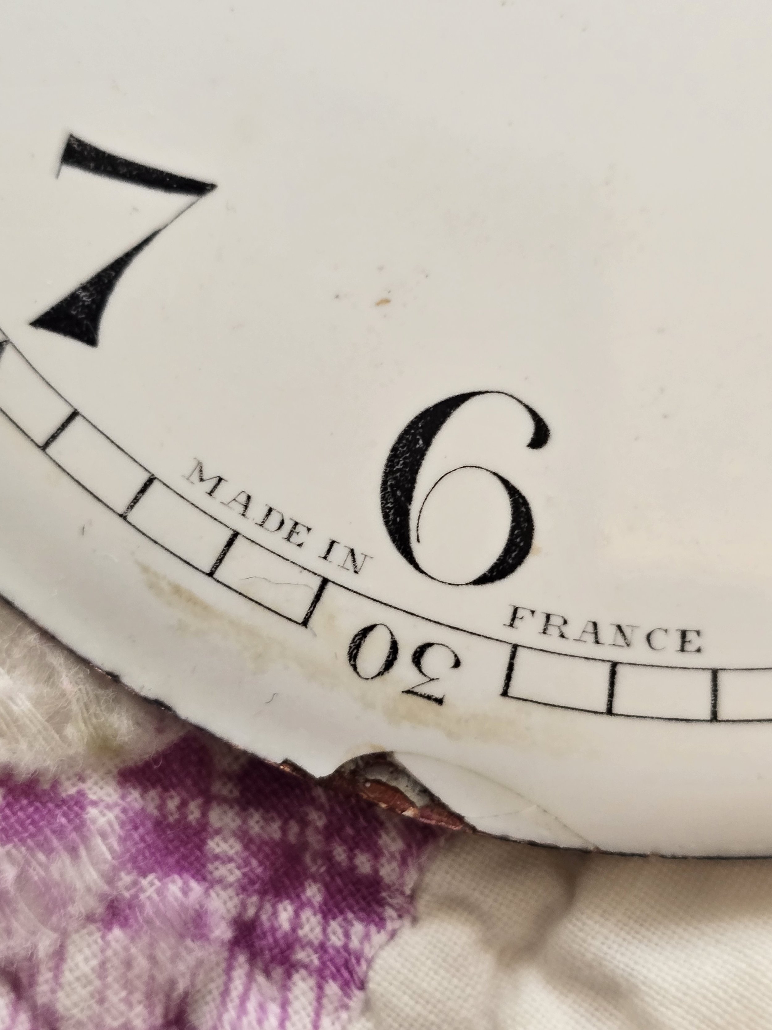 Vintage French clock face showing elegant black numerals on a white enamel background