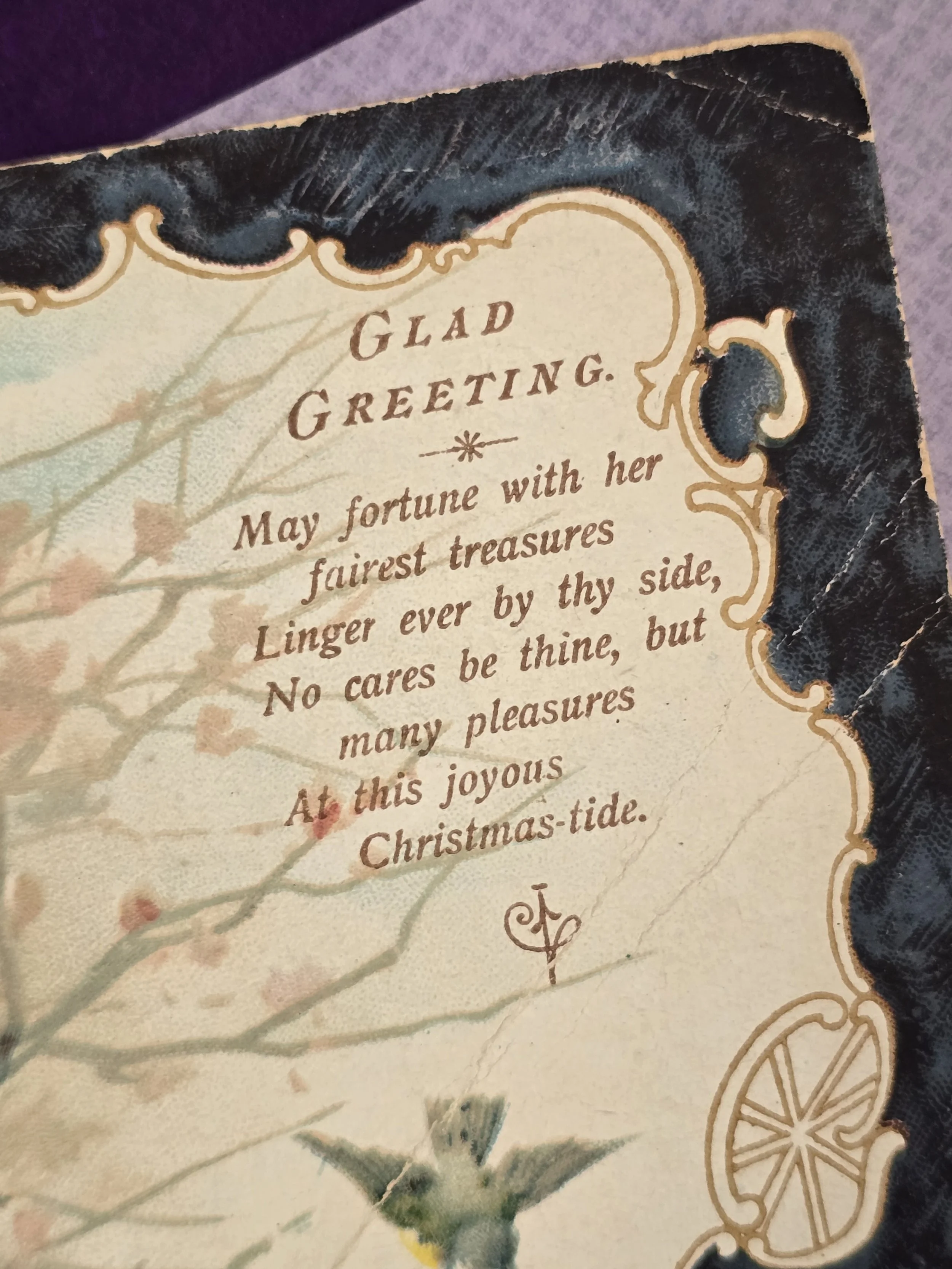 Detail of antique greeting card showing the printed "Glad Greeting" verse and ornate border decoration.