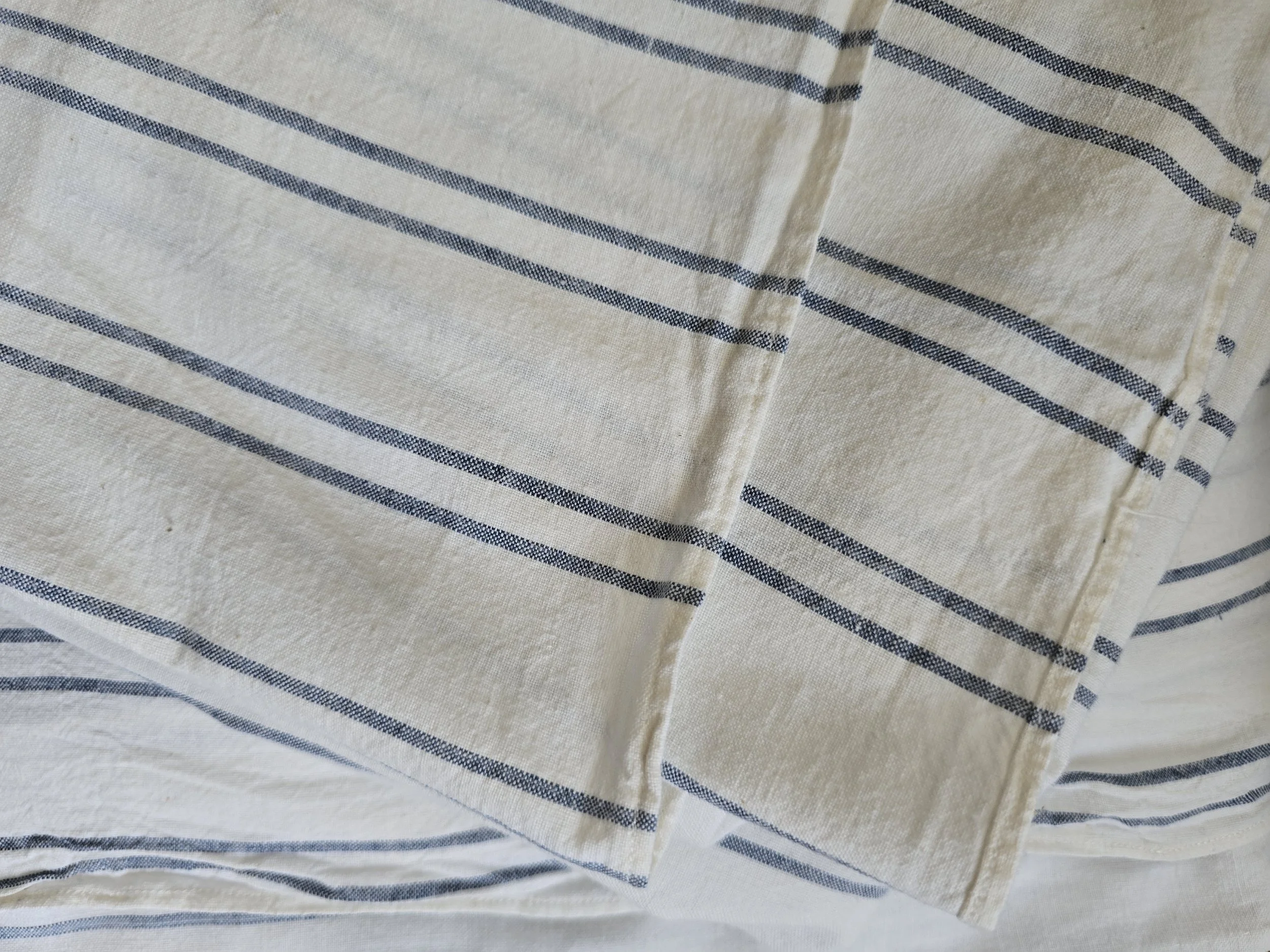 Antique blue stripe cotton sheet with traditional pieced construction laid flat to show its full size.