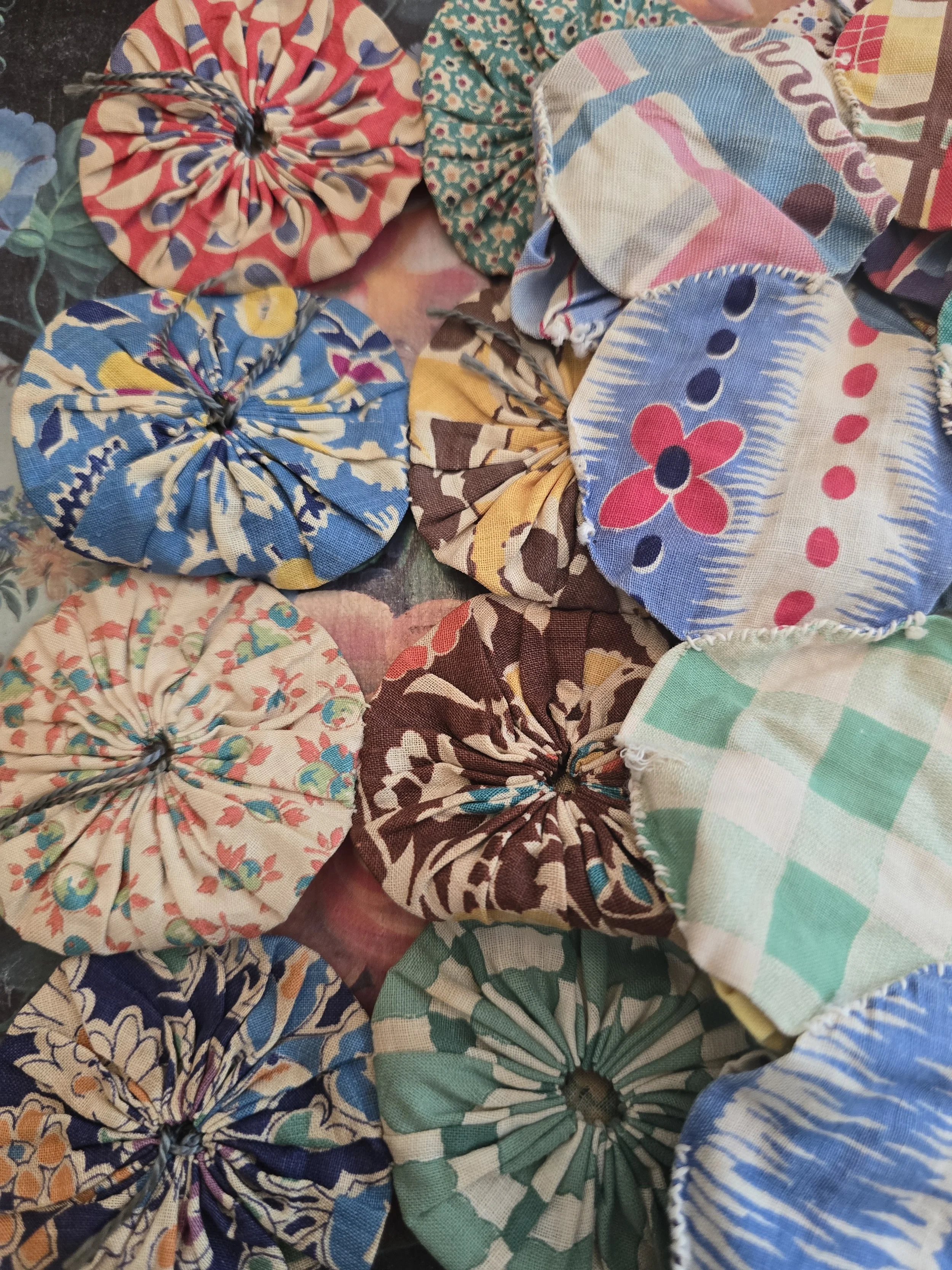 Collection of vintage handmade fabric yo-yos in assorted floral and geometric cotton prints
