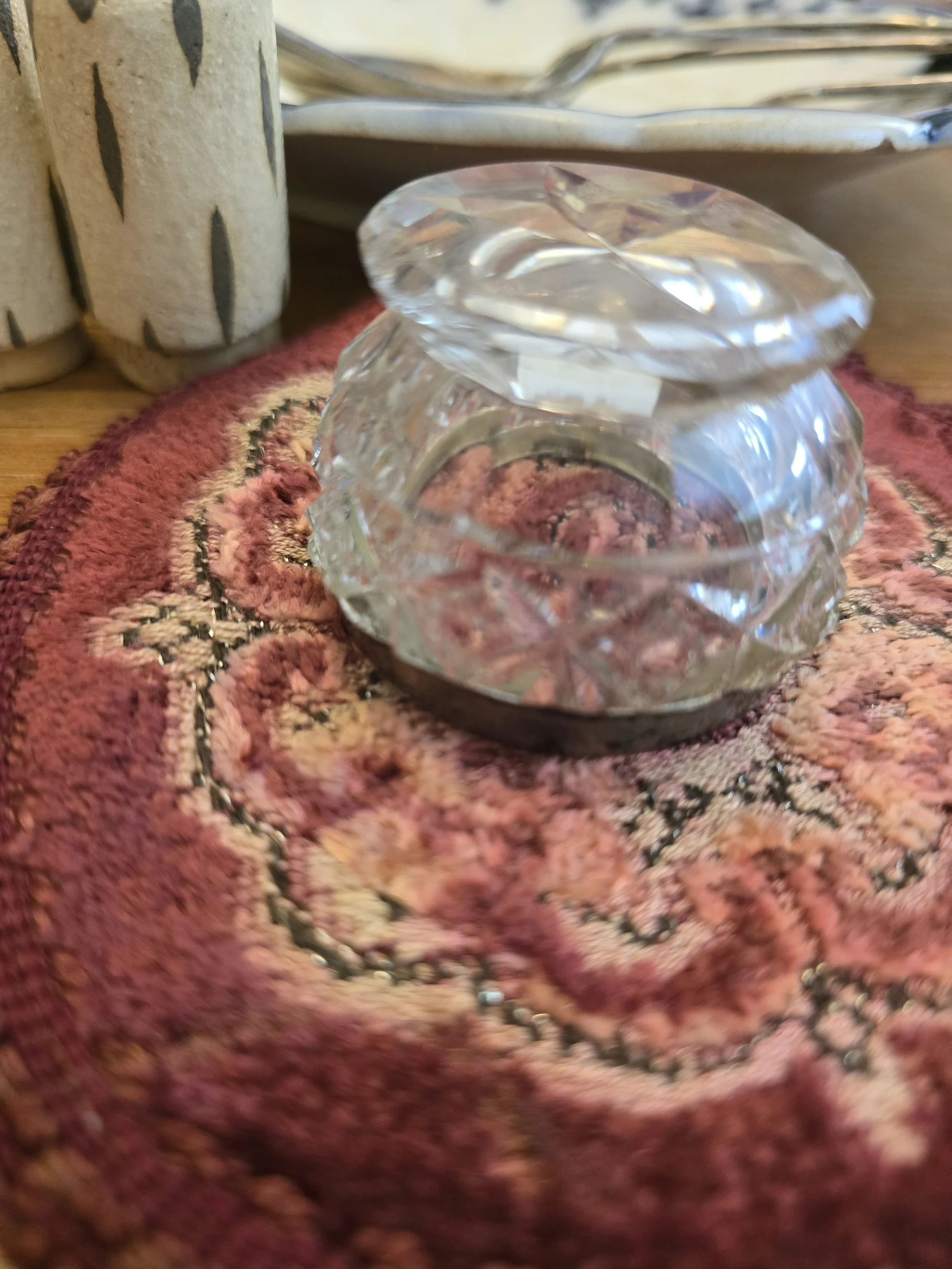 Base of antique cut glass salt cellar showing faceted glass foot and age-related wear.