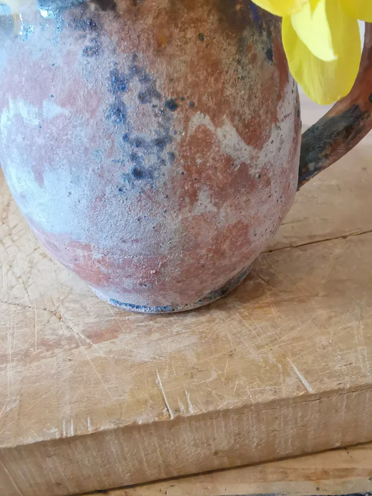 Antique French rustic pitcher styled as a vase with fresh spring flowers