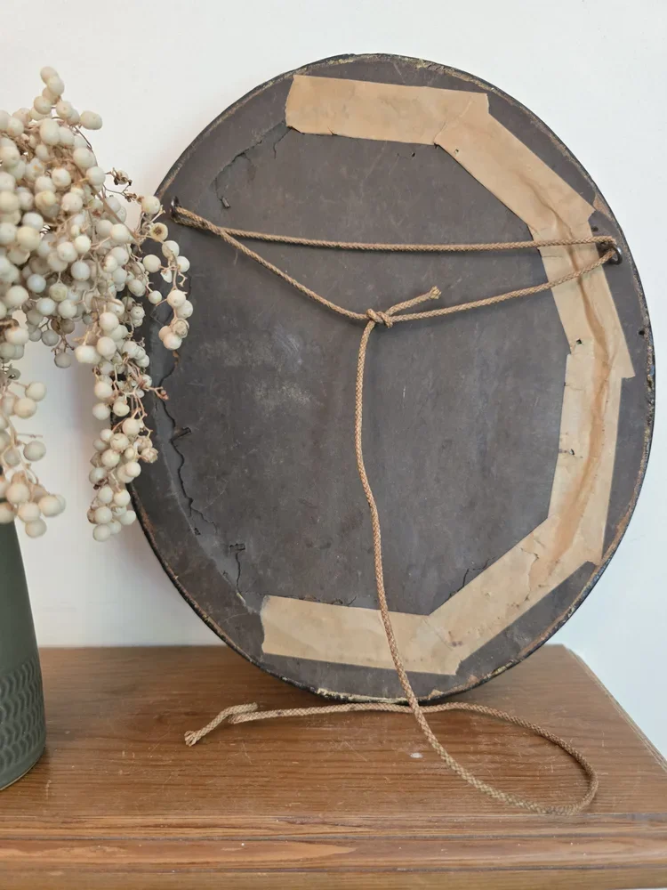 Back of antique oval convex frame with string and paper backing.