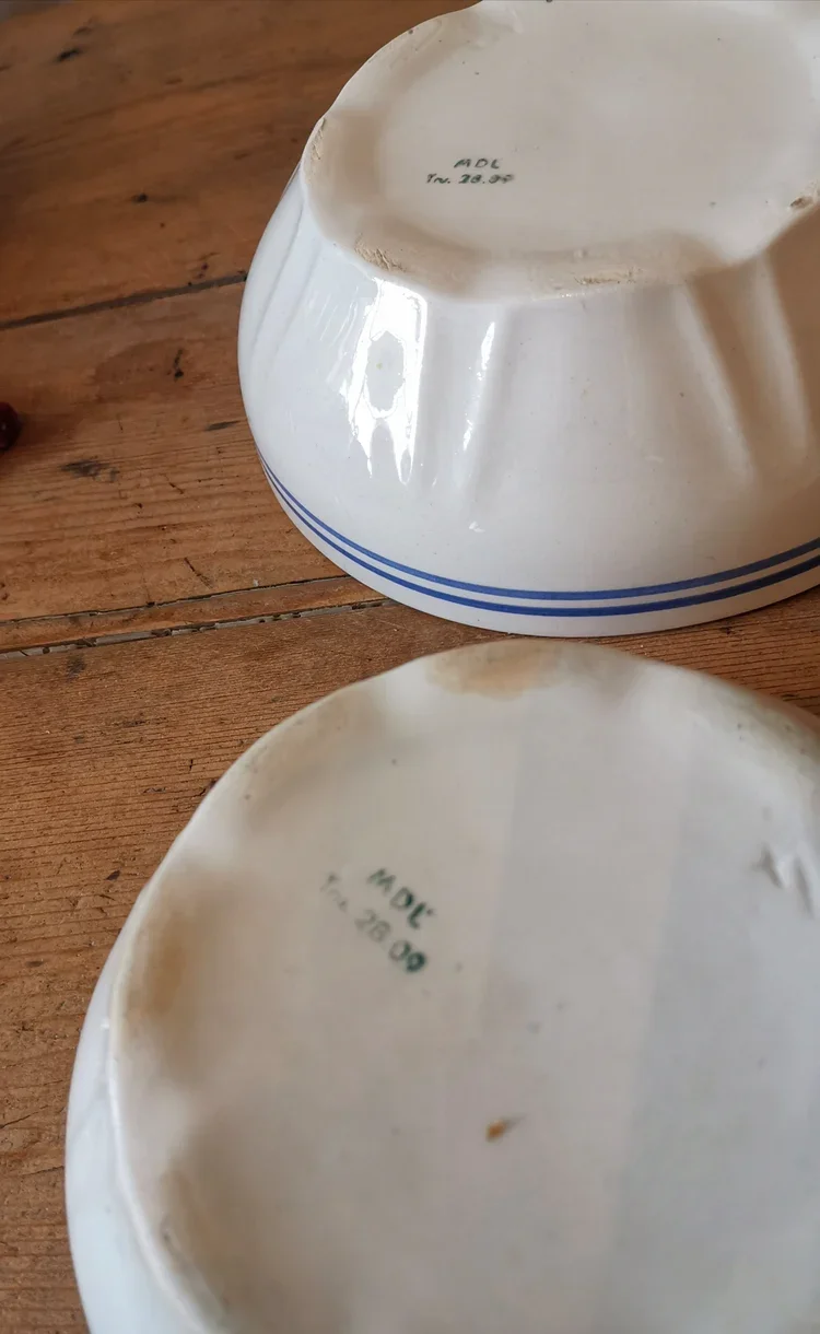 Underside of Moulin de Loups bowls marked MDL, confirming vintage French faience origin.