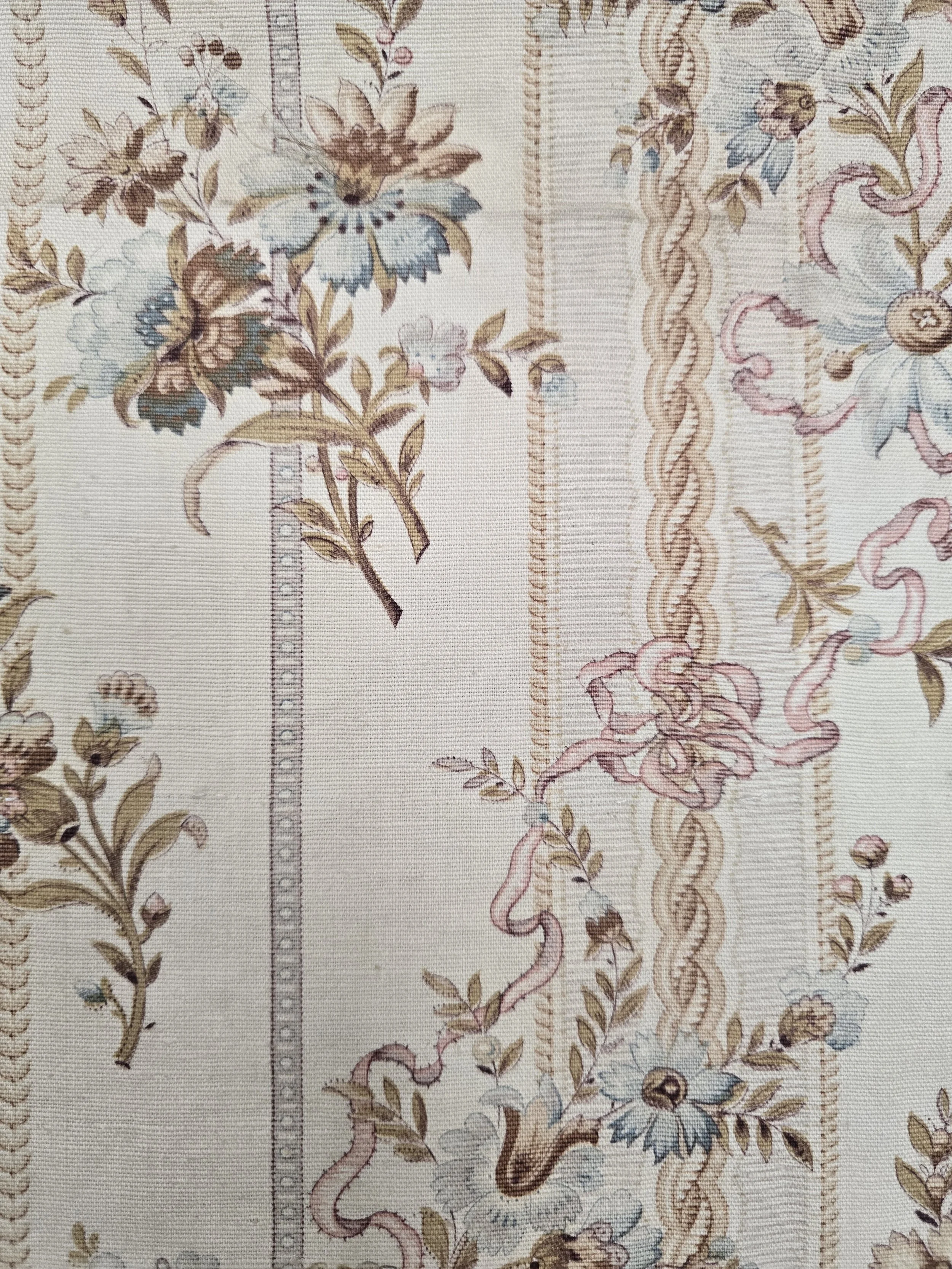 Close-up of faded floral and ribbon design on antique French textile