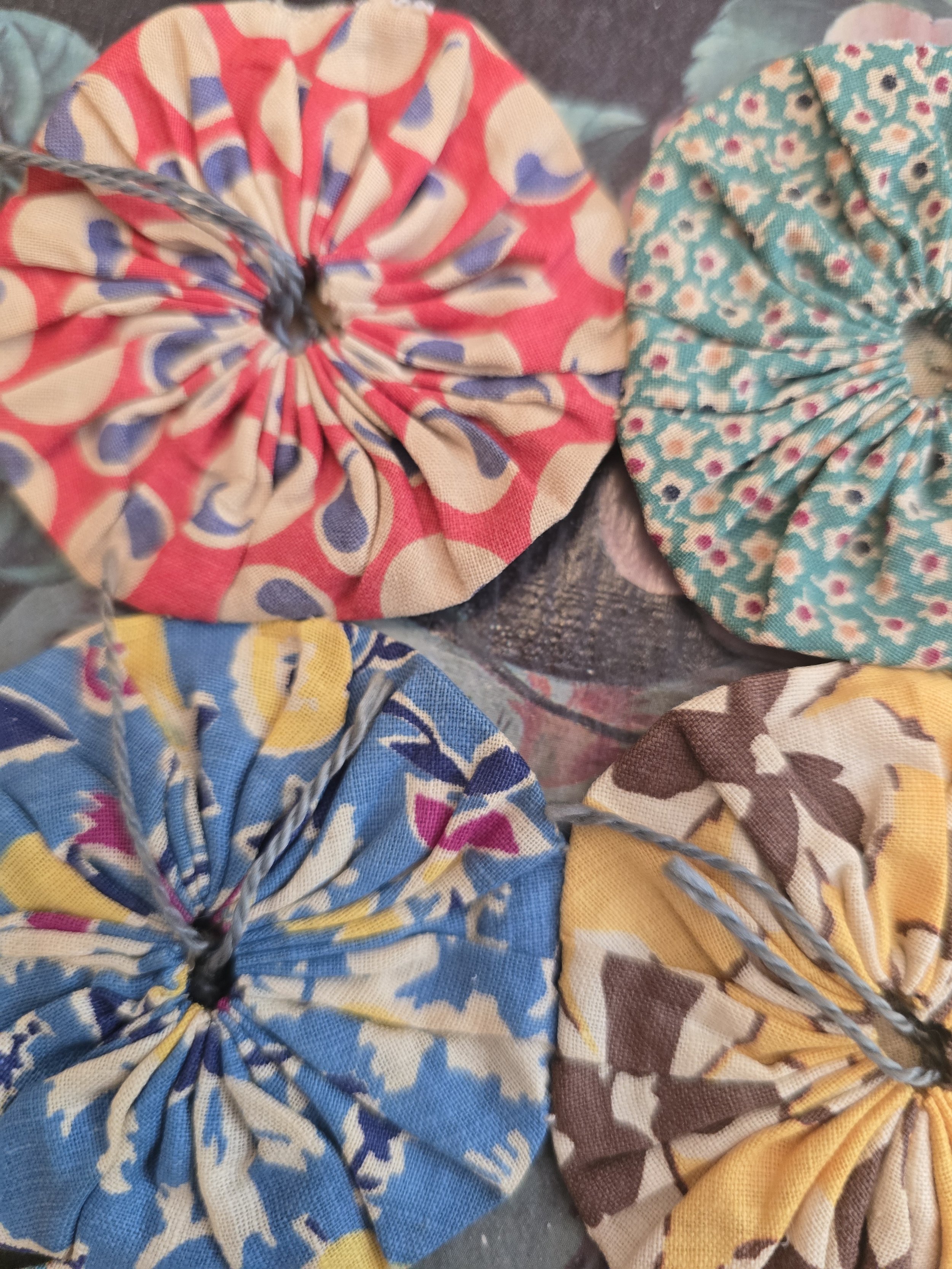 Assorted gathered fabric rosettes suitable for quilting and textile art projects.
