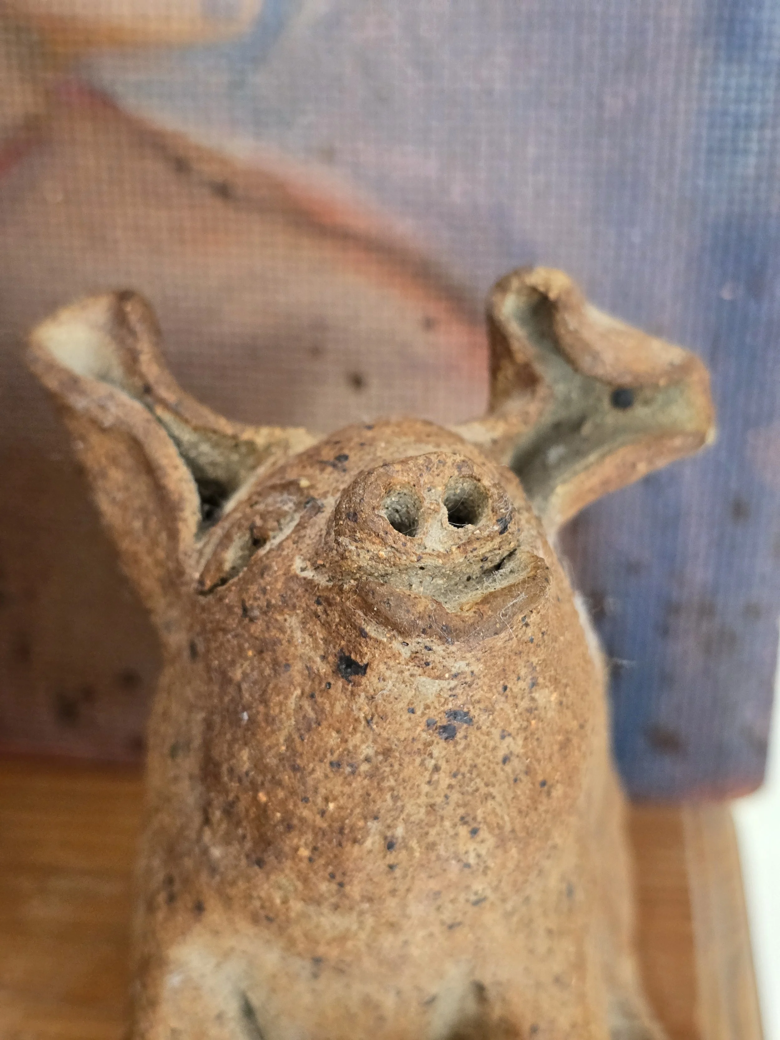 Close-up of primitive pottery pig showing irregular handmade modelling and naturally speckled surface. SEO title