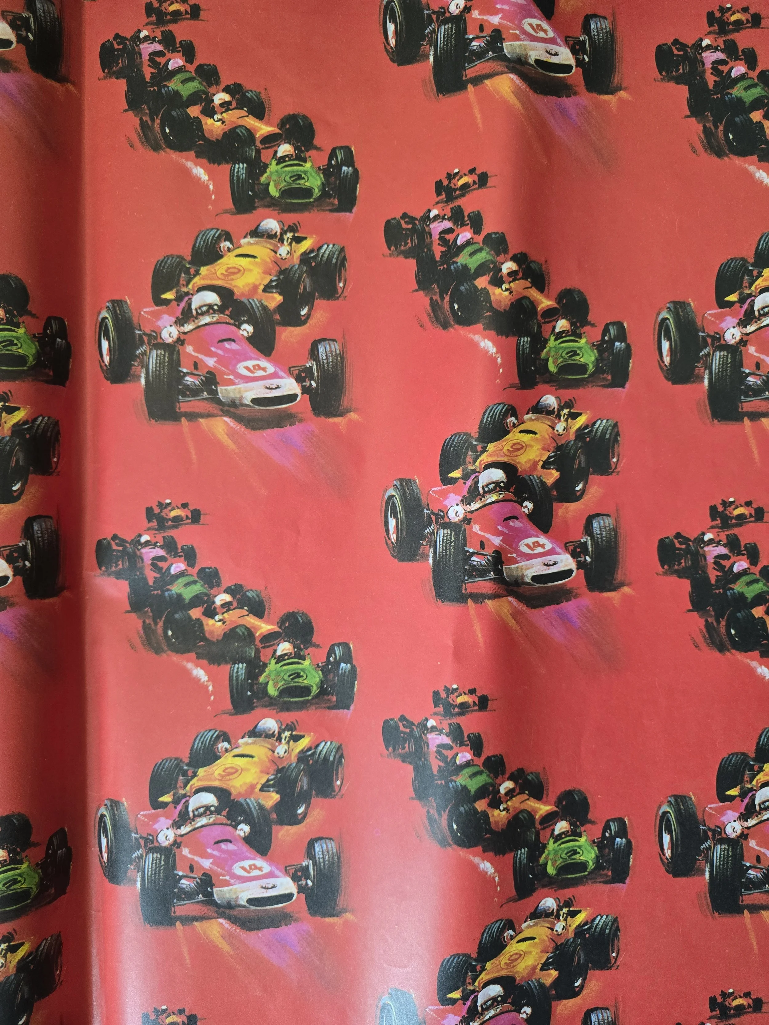 Retro red wrapping paper featuring Formula 1 style racing cars