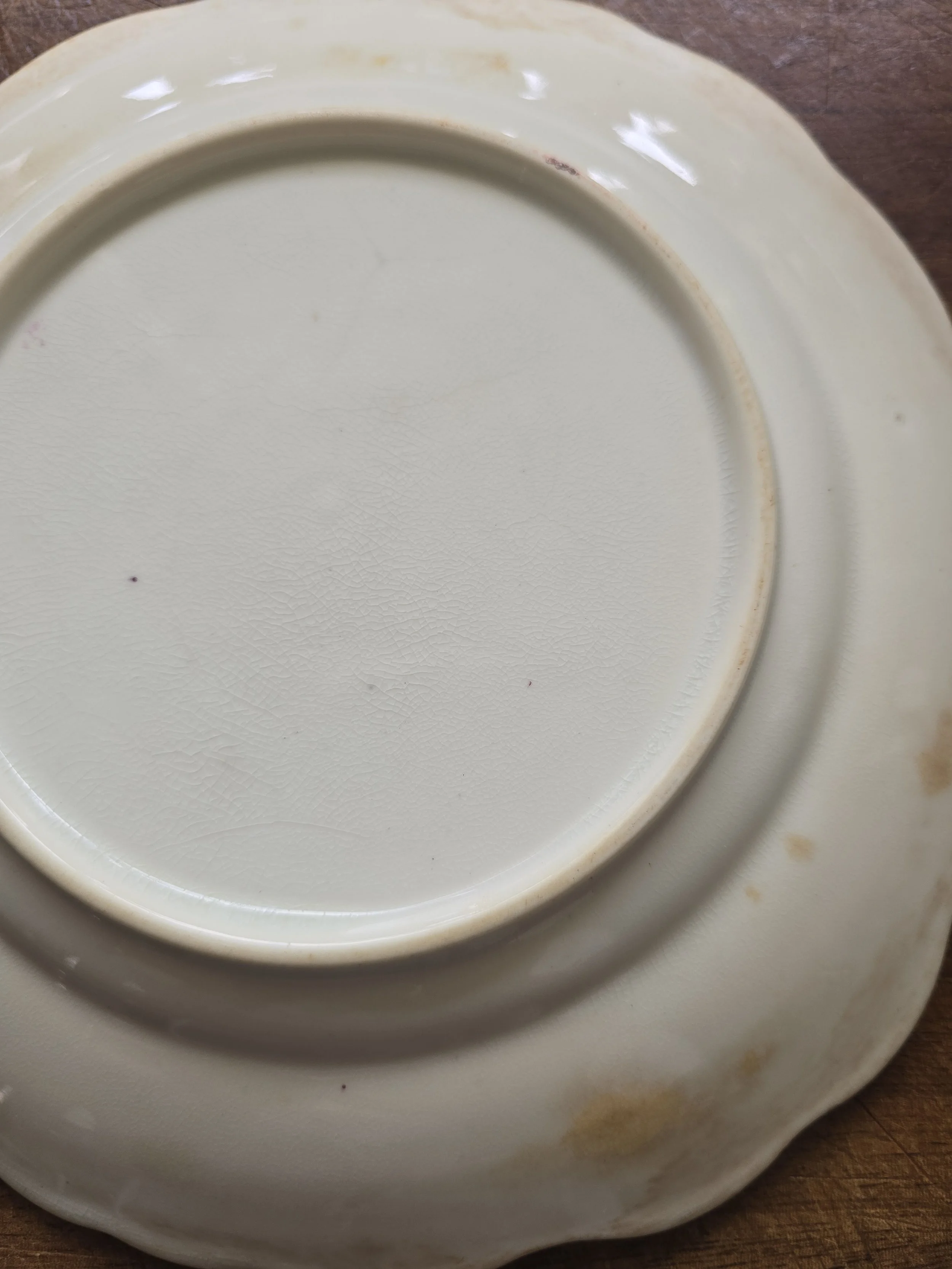 Victorian floral china plate with age-related crazing and soft cream glaze.