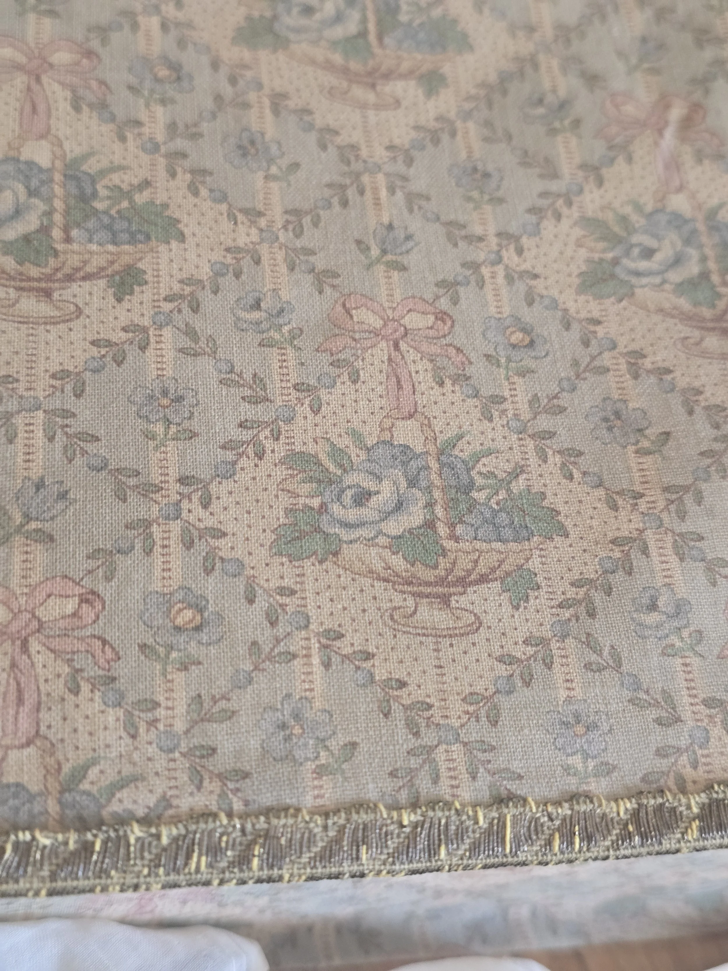 Side of antique French boudoir box showing original rose basket fabric and aged metallic edging.