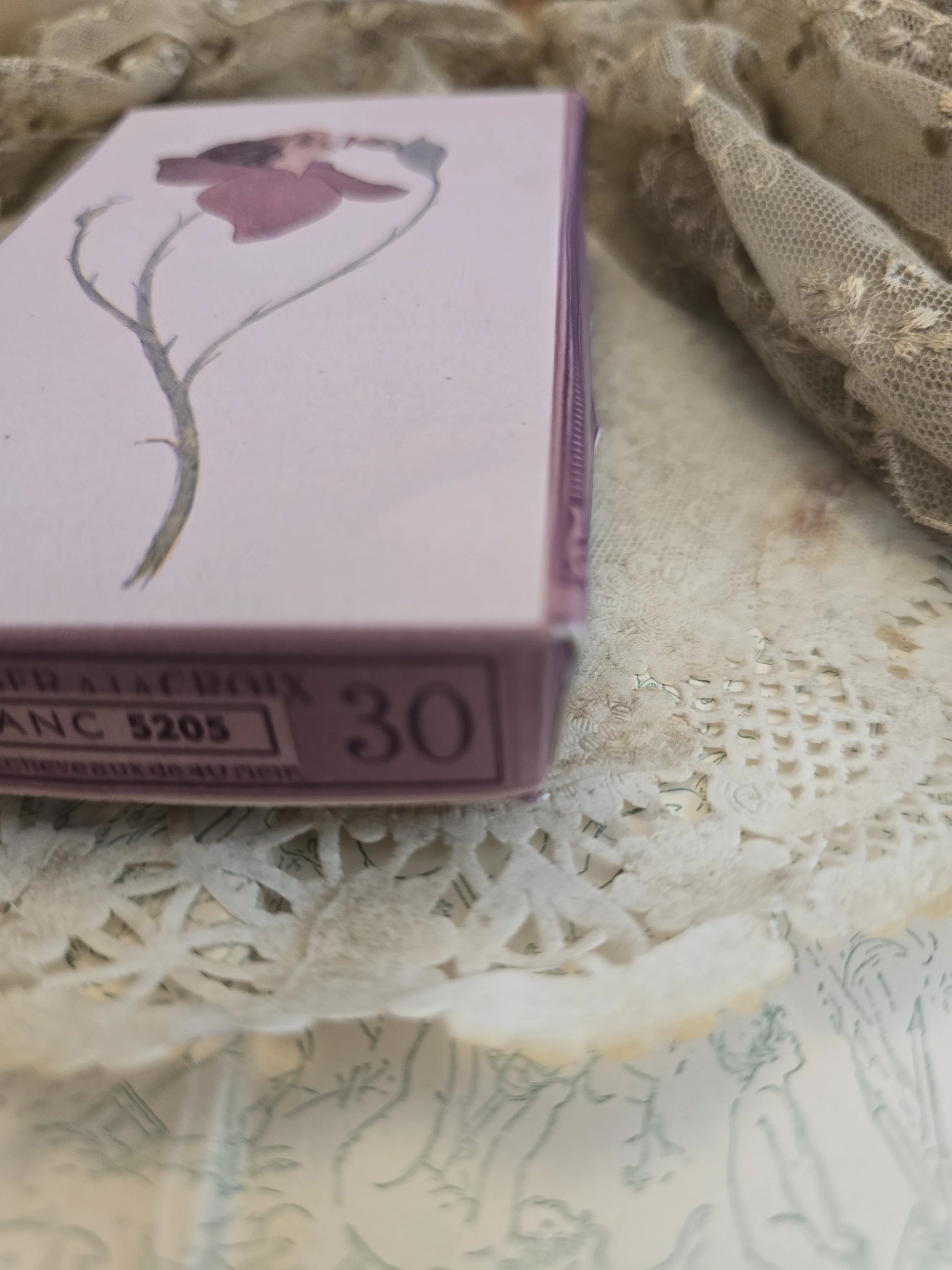 Handmade Puff Blossom keepsake box displayed with antique lace, showing the illustrated lid and mauve sides.