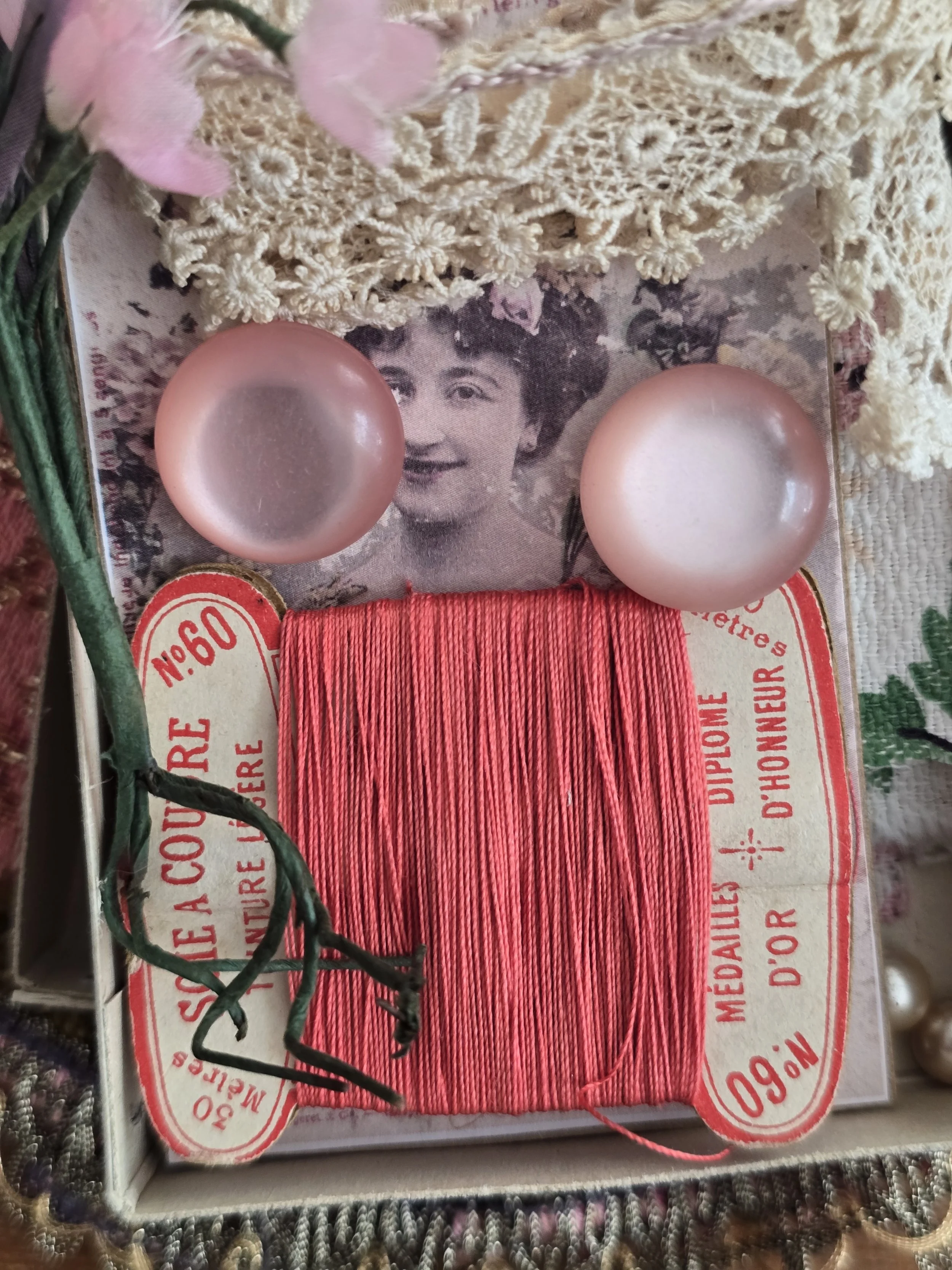 Curated vintage French sewing collection arranged inside an original Cartier-Bresson embroidery thread box with lace, haberdashery and pink sewing notions.