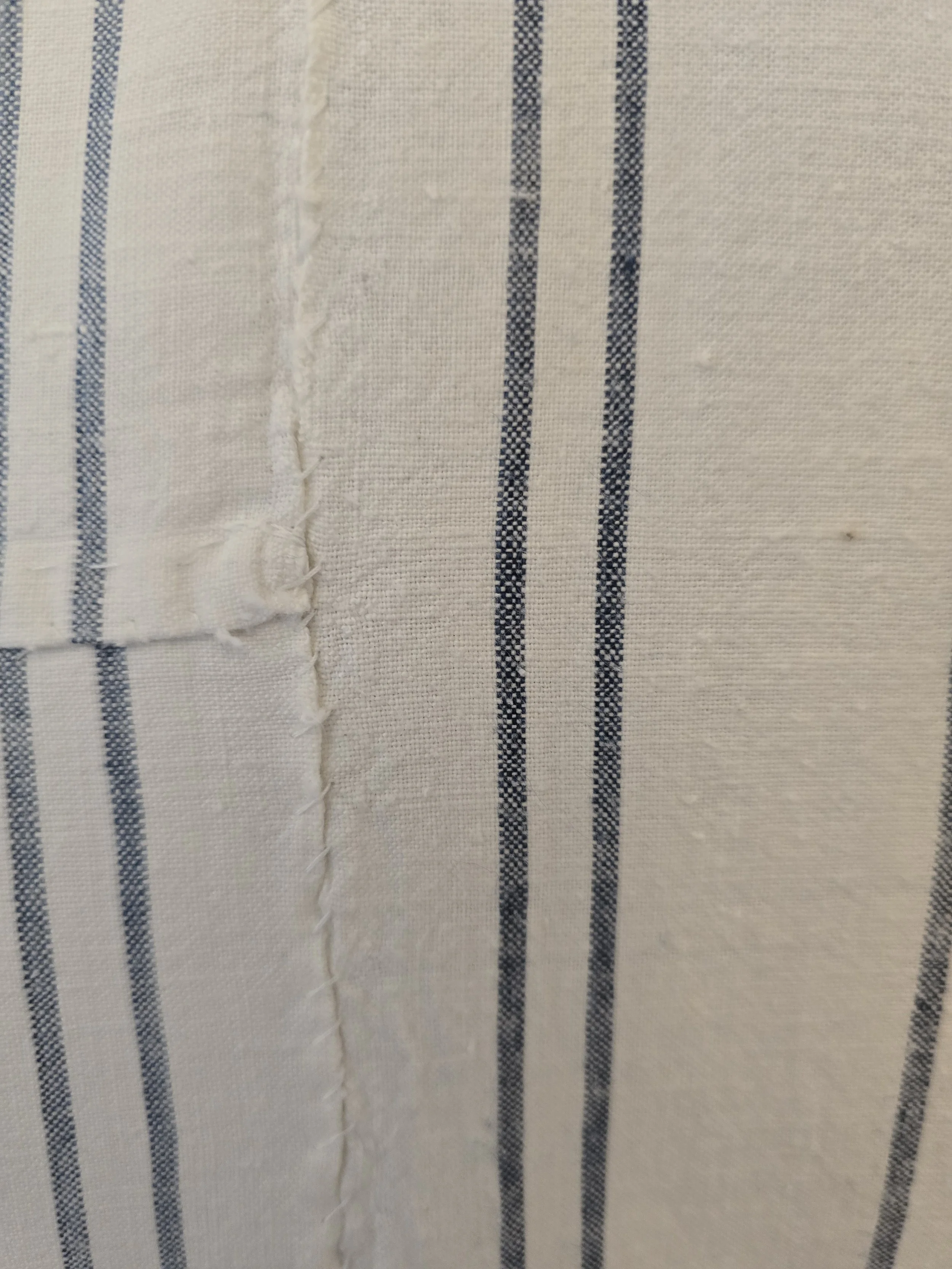 Close-up of the woven blue ticking stripes and soft antique cotton fabric.