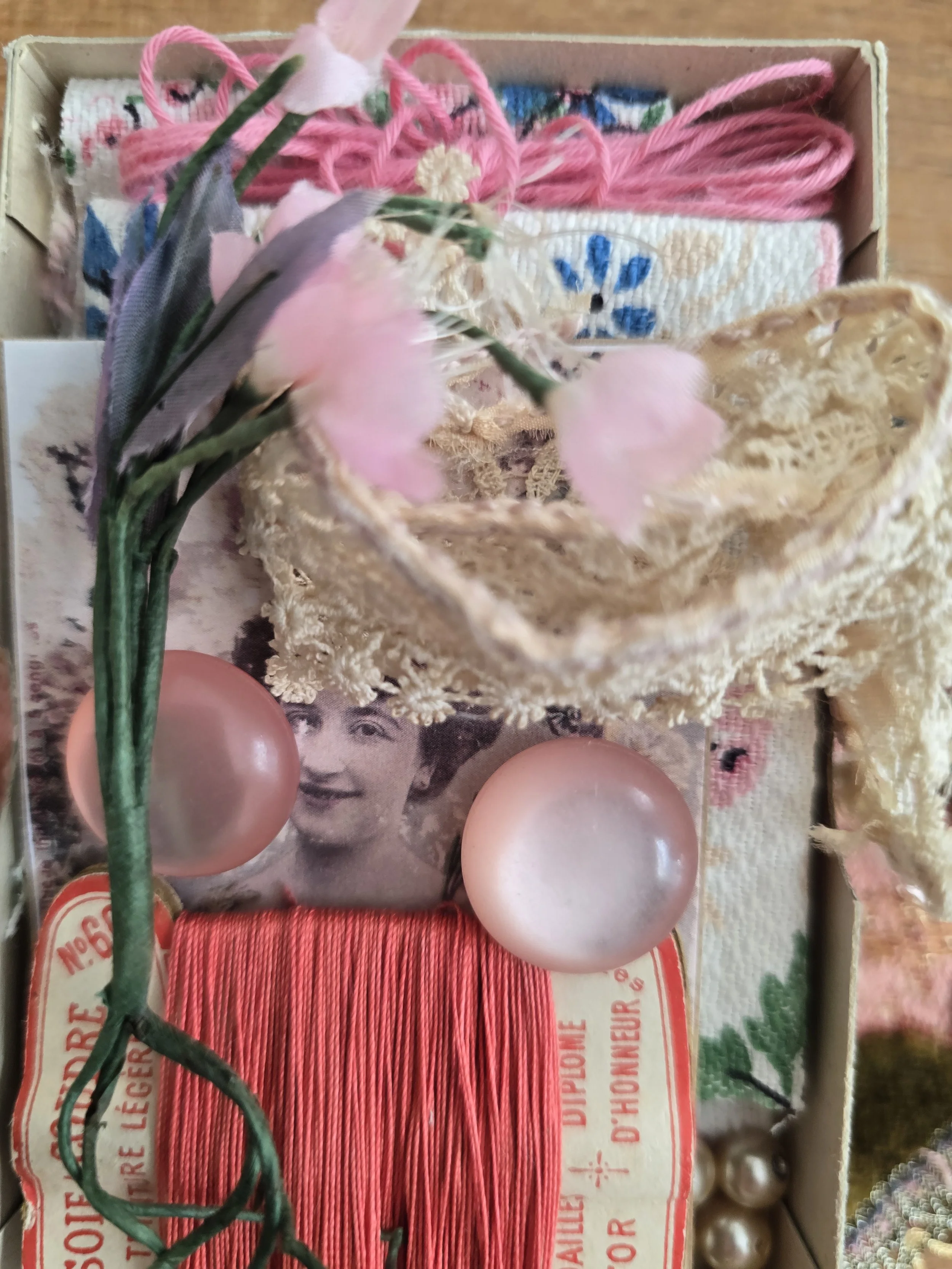 Vintage French embroidery thread wrapped on an original thread card with faux pearls and floral fabric inside an original sewing box.