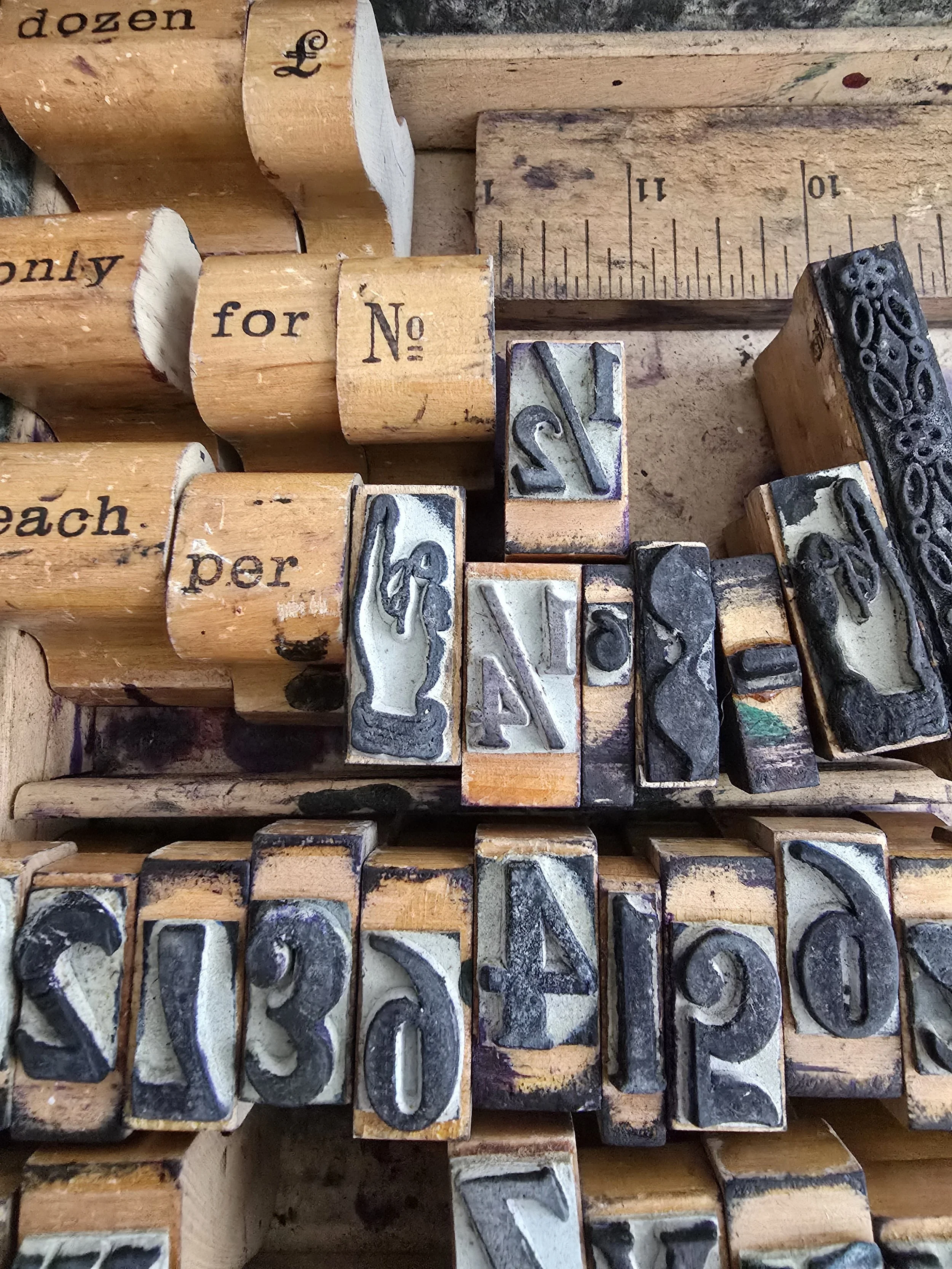 Close-up of antique rubber stamps with ruler inside original box.