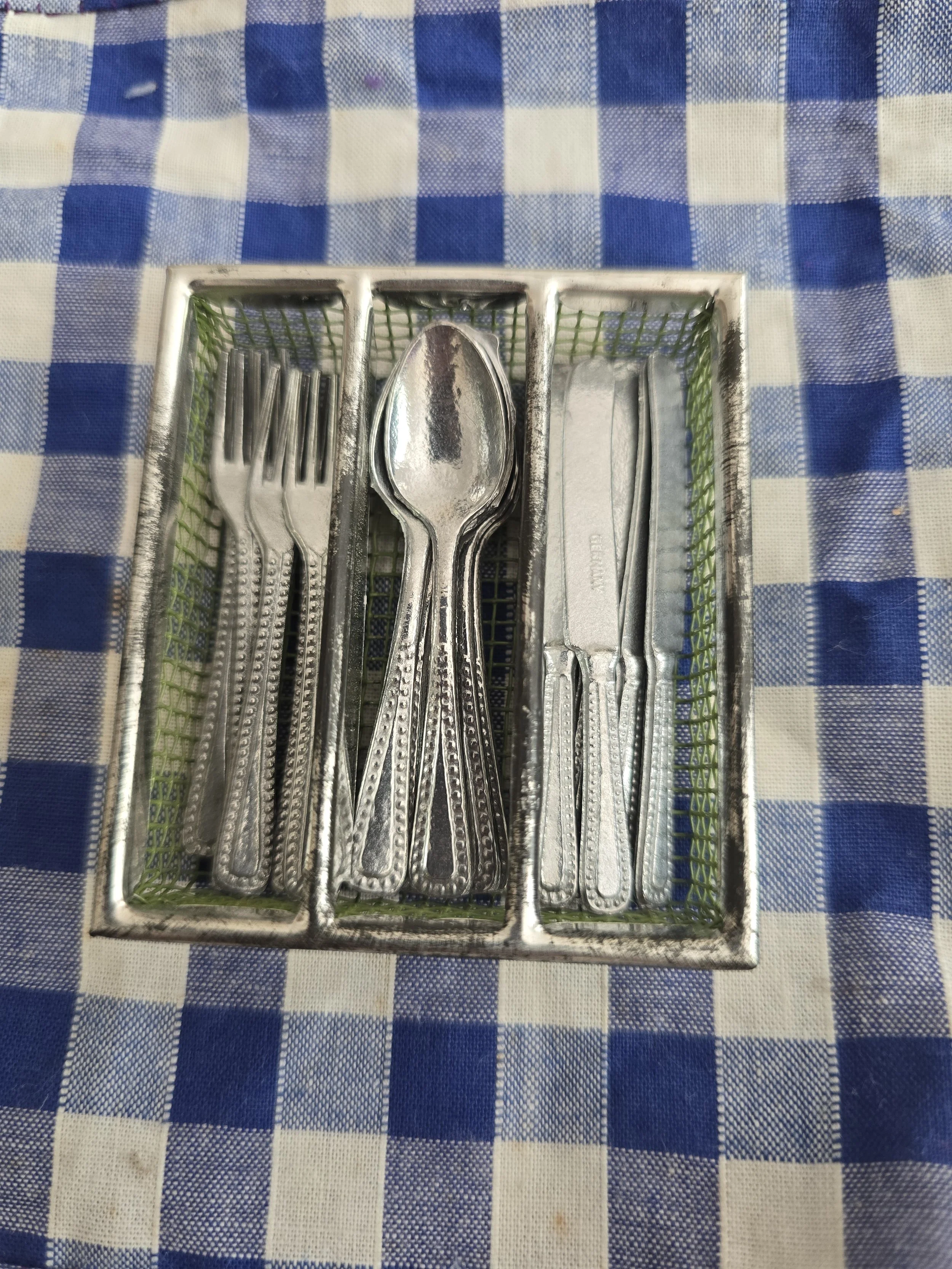 Vintage miniature German cutlery set with forks, spoons and knives in the original tray.