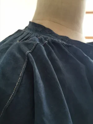Shoulder pleat detail showing hand stitches on antique biaude.
