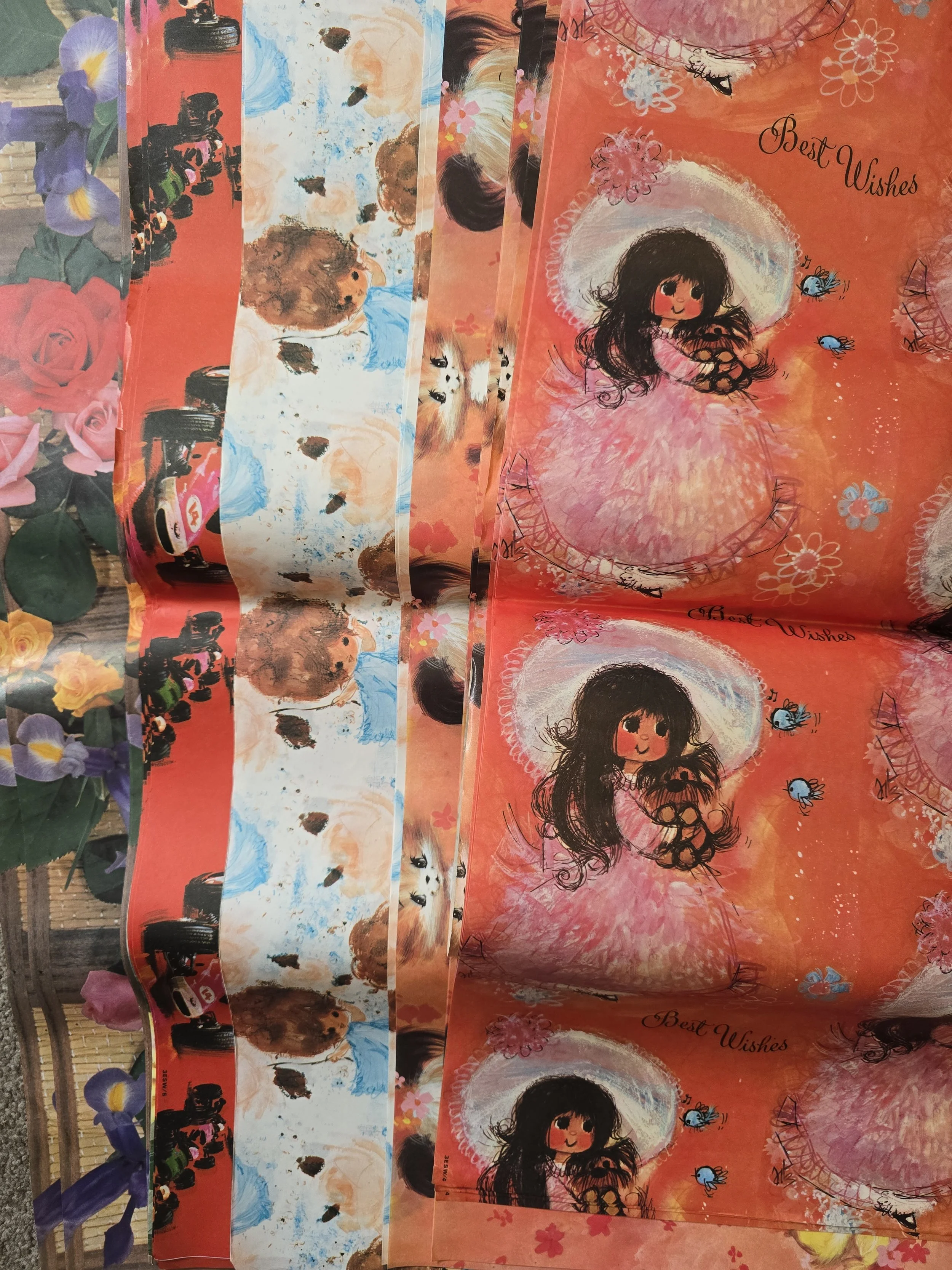 Mixed stack of kawaii vintage 1970s wrapping papers showing girl, animal, and car prints