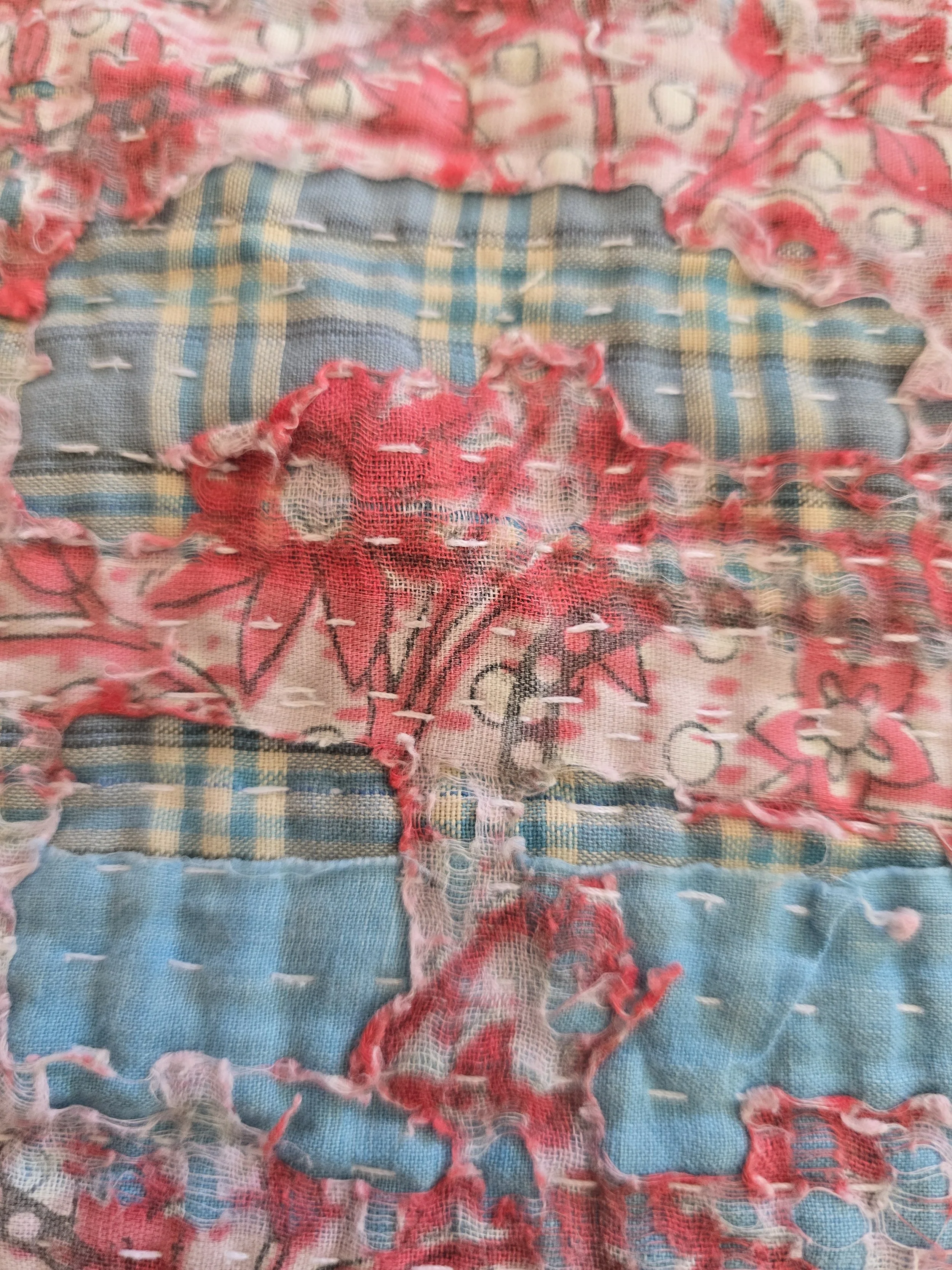 Antique-style kantha textile with distressed areas revealing checked cotton beneath hand-stitched layers.