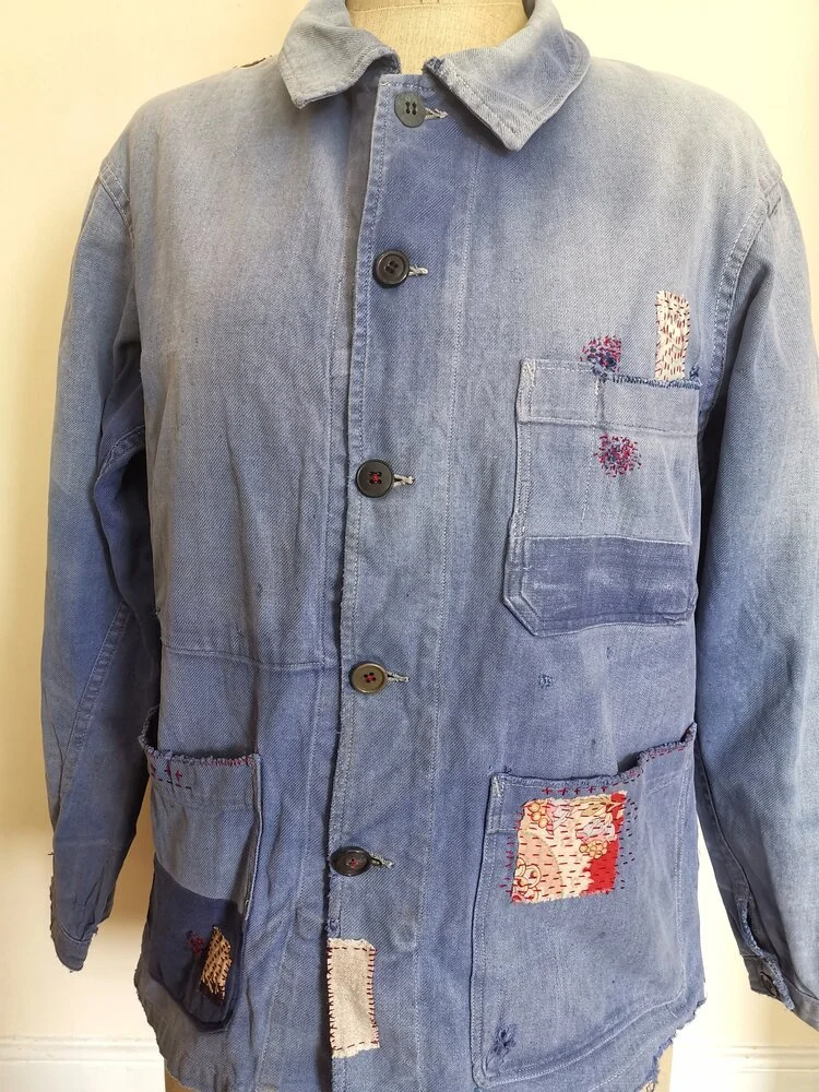 Full view of vintage French chore jacket with visible patching and mending