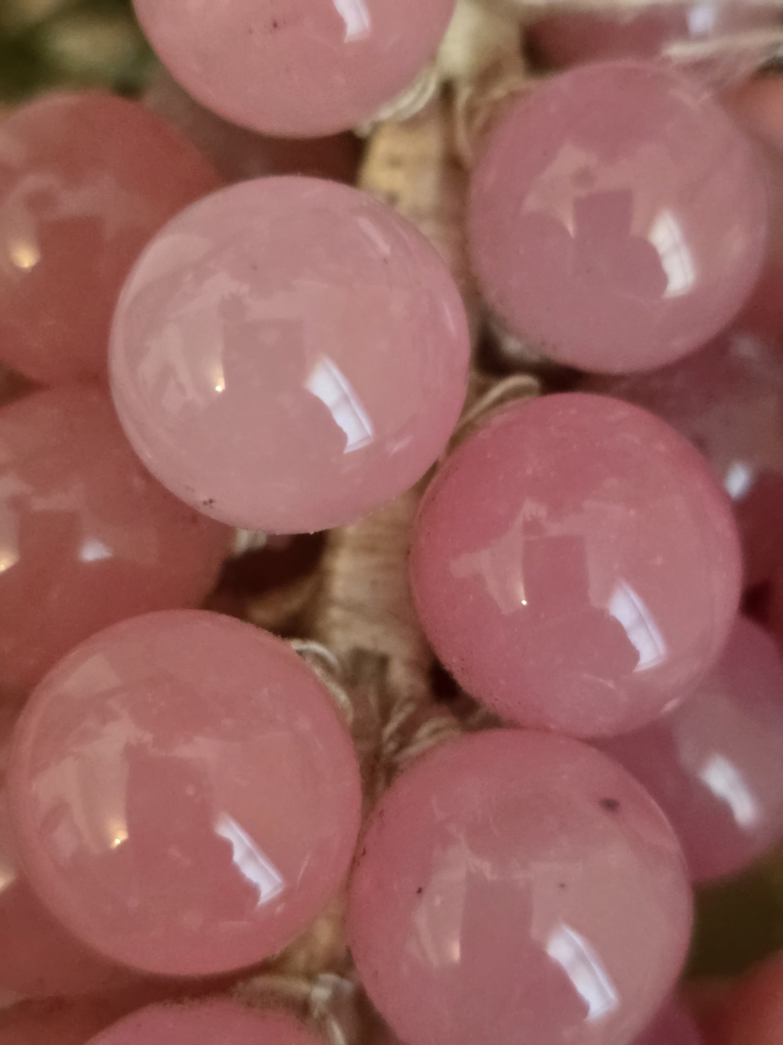 Detail of translucent pink glass grapes showing variations within the vintage glass.