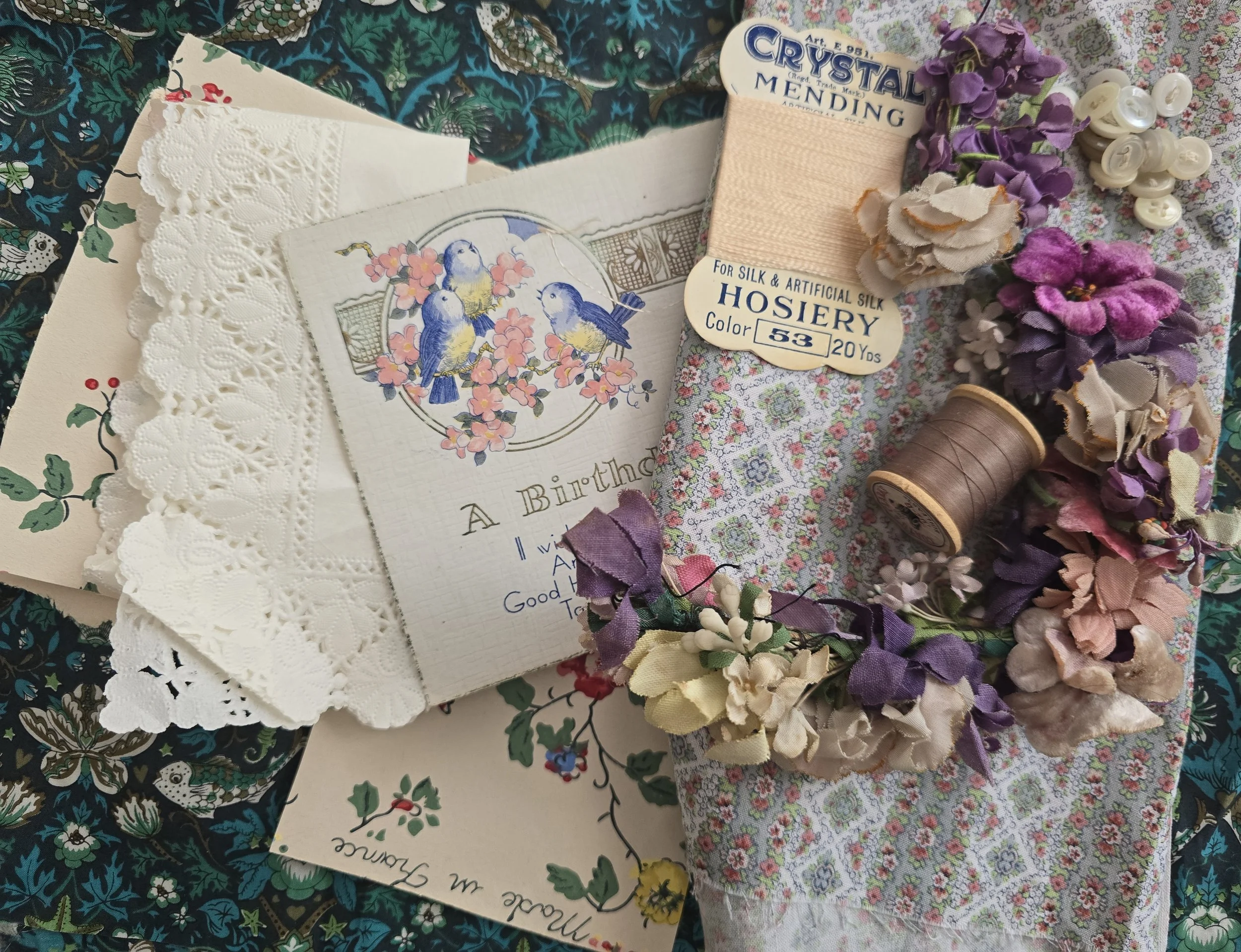 curated vintage textile bundle with teal patterned fabric and layered ephemera