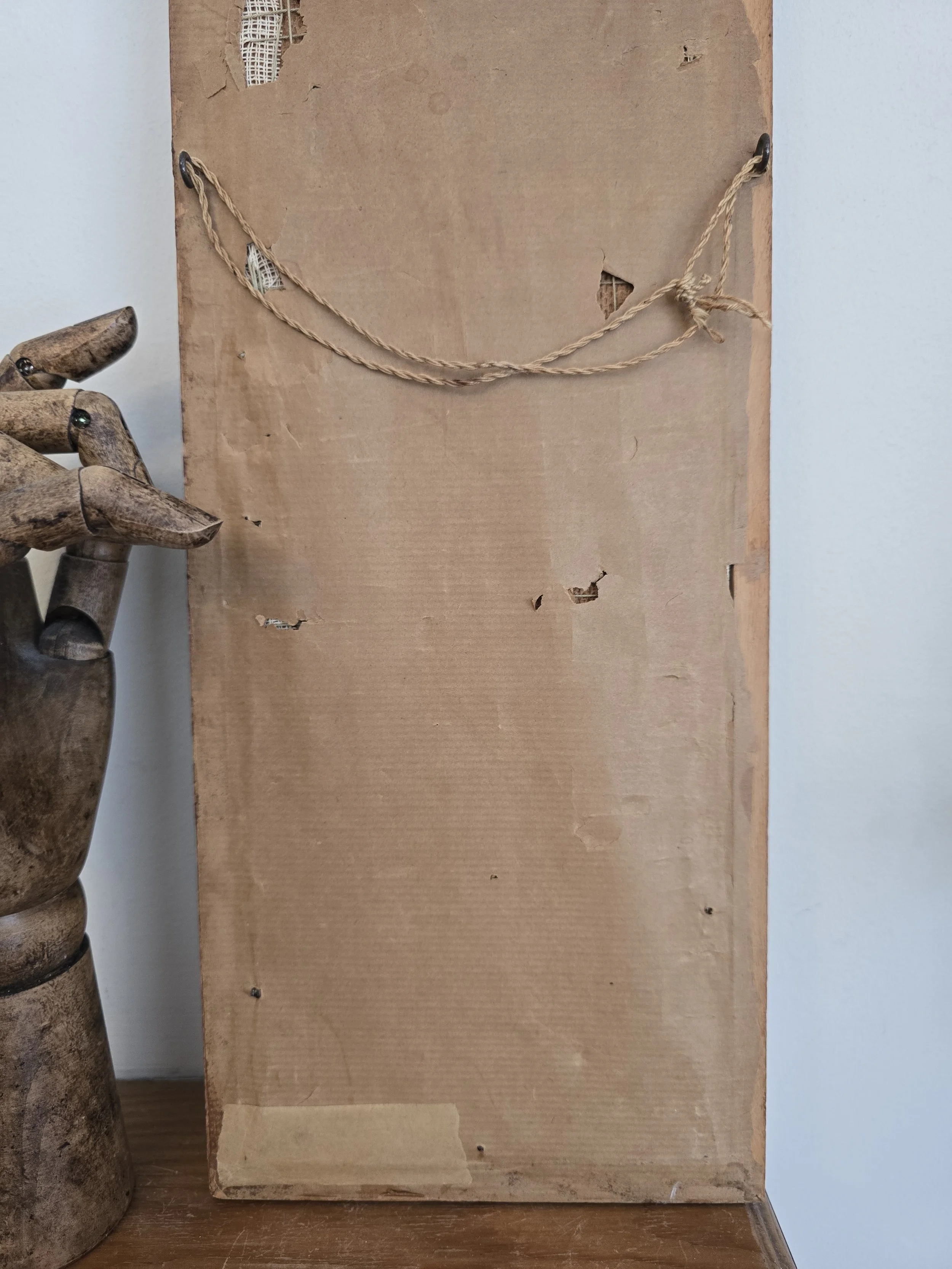 Reverse of vintage framed needlework showing original worn brown paper backing
