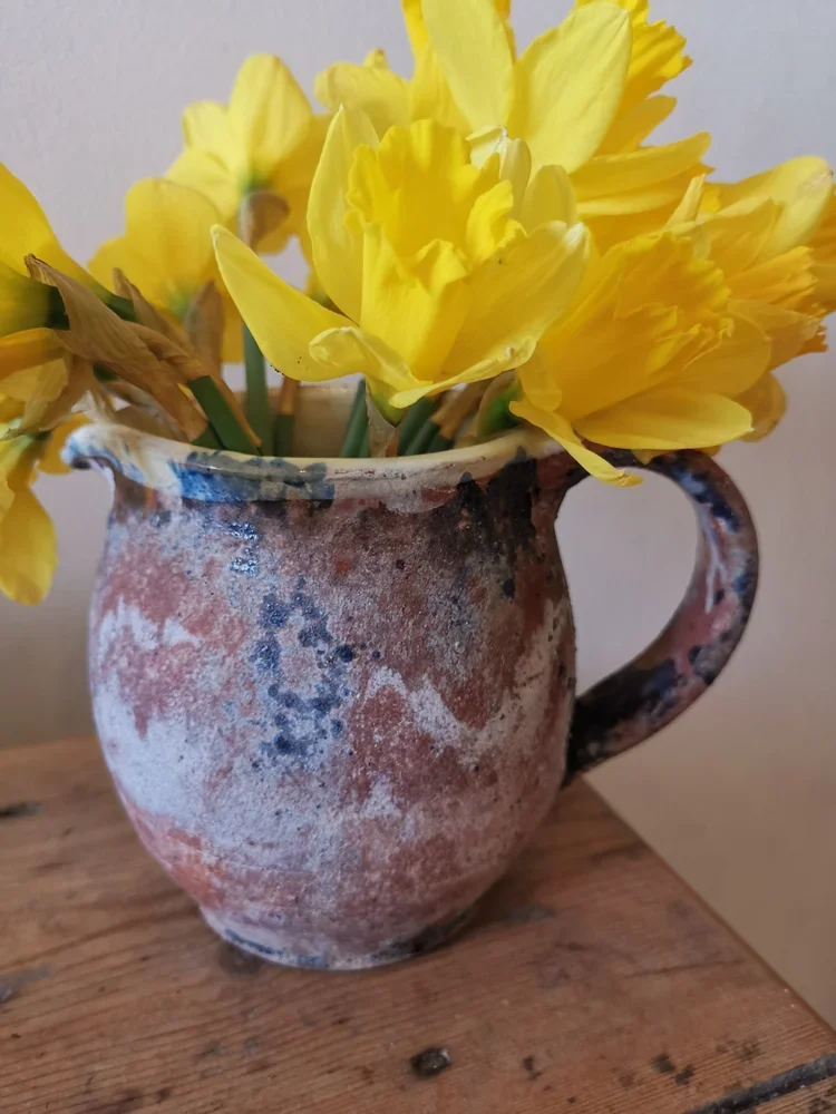 Antique French rustic terracotta pitcher with natural aged patina on wooden table