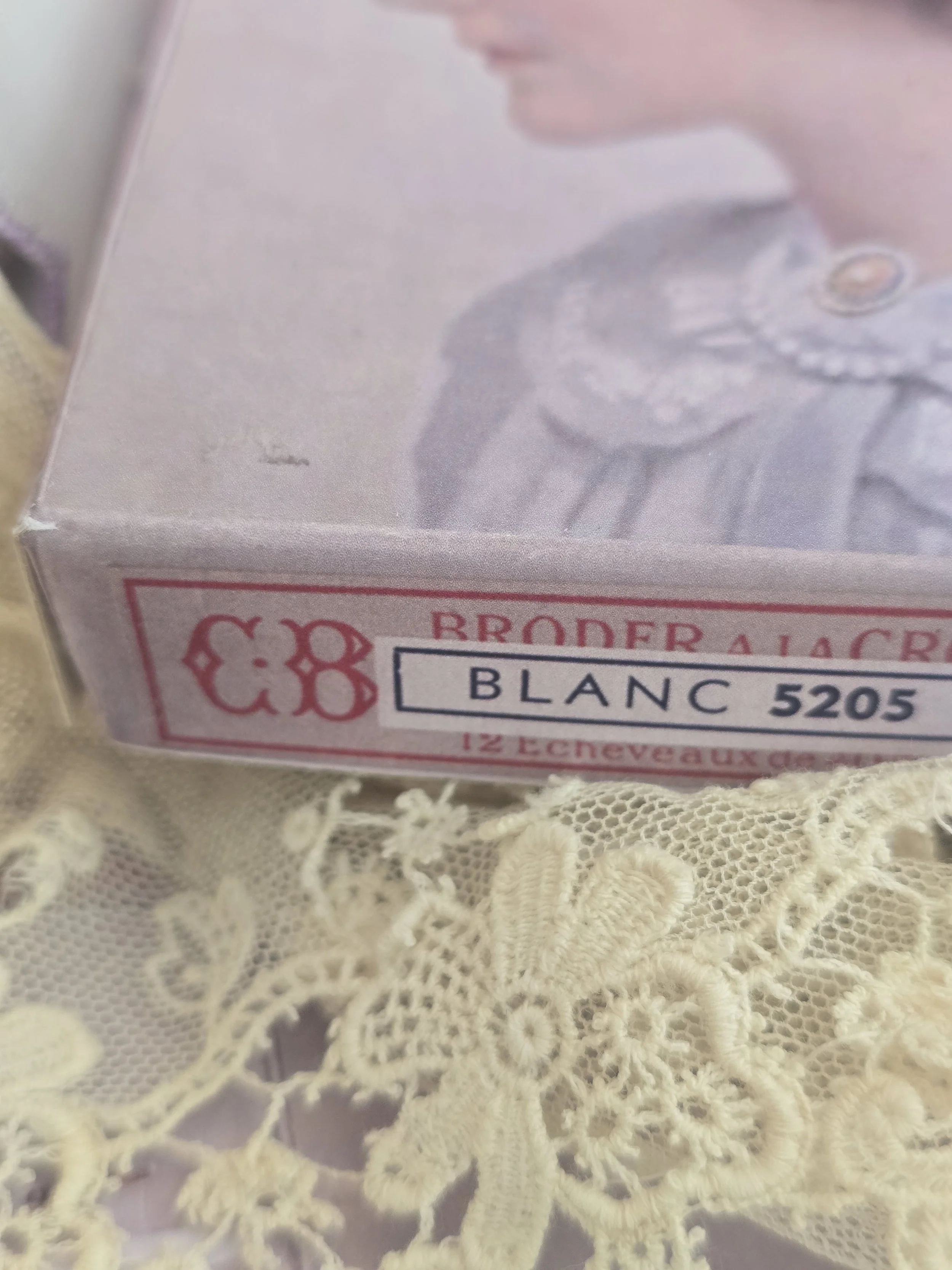 Close-up of the vintage French Broderie à la Croix label on the side of the handmade portrait box.