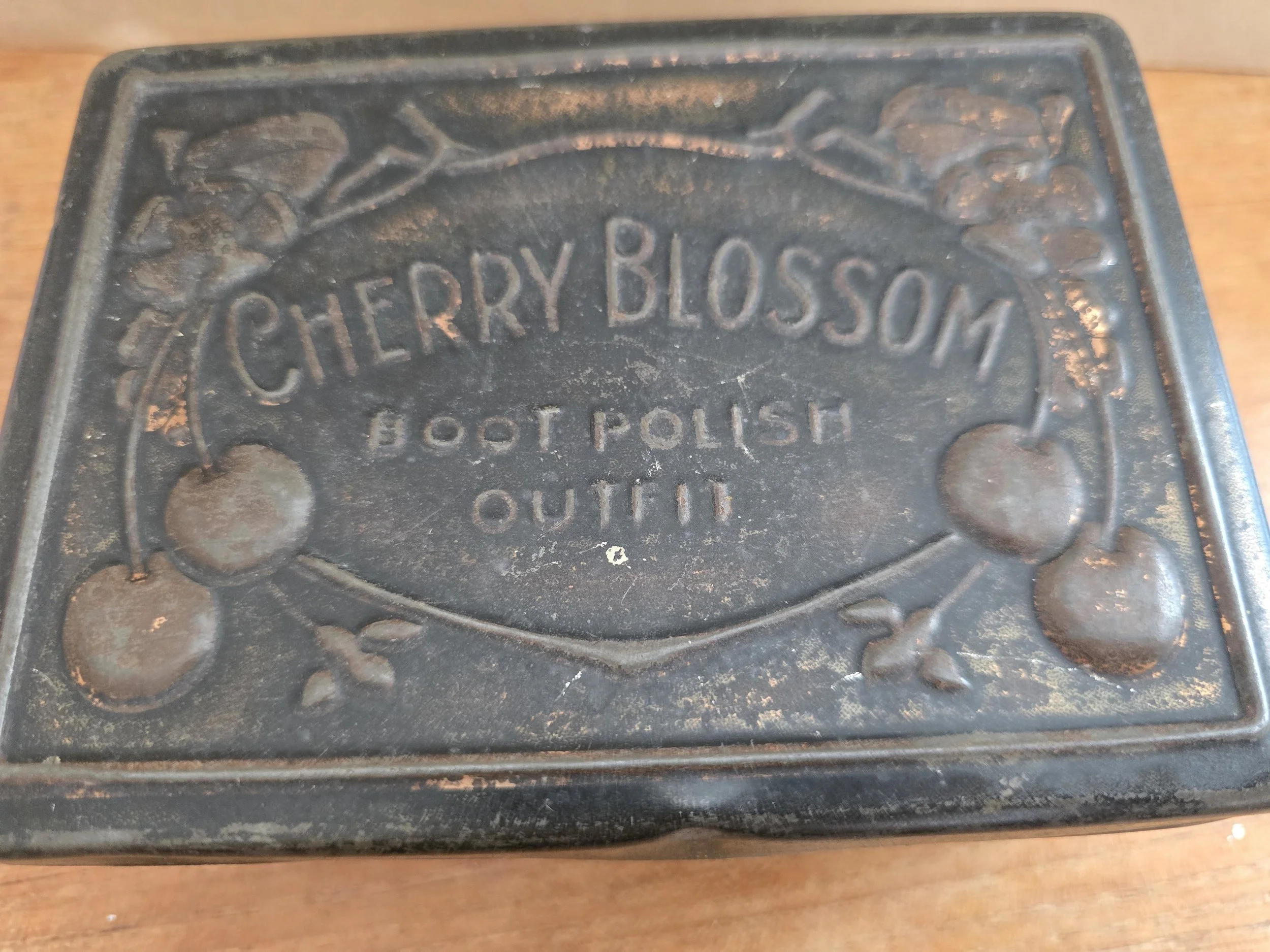 Vintage boot polish storage tin with cherry decoration.