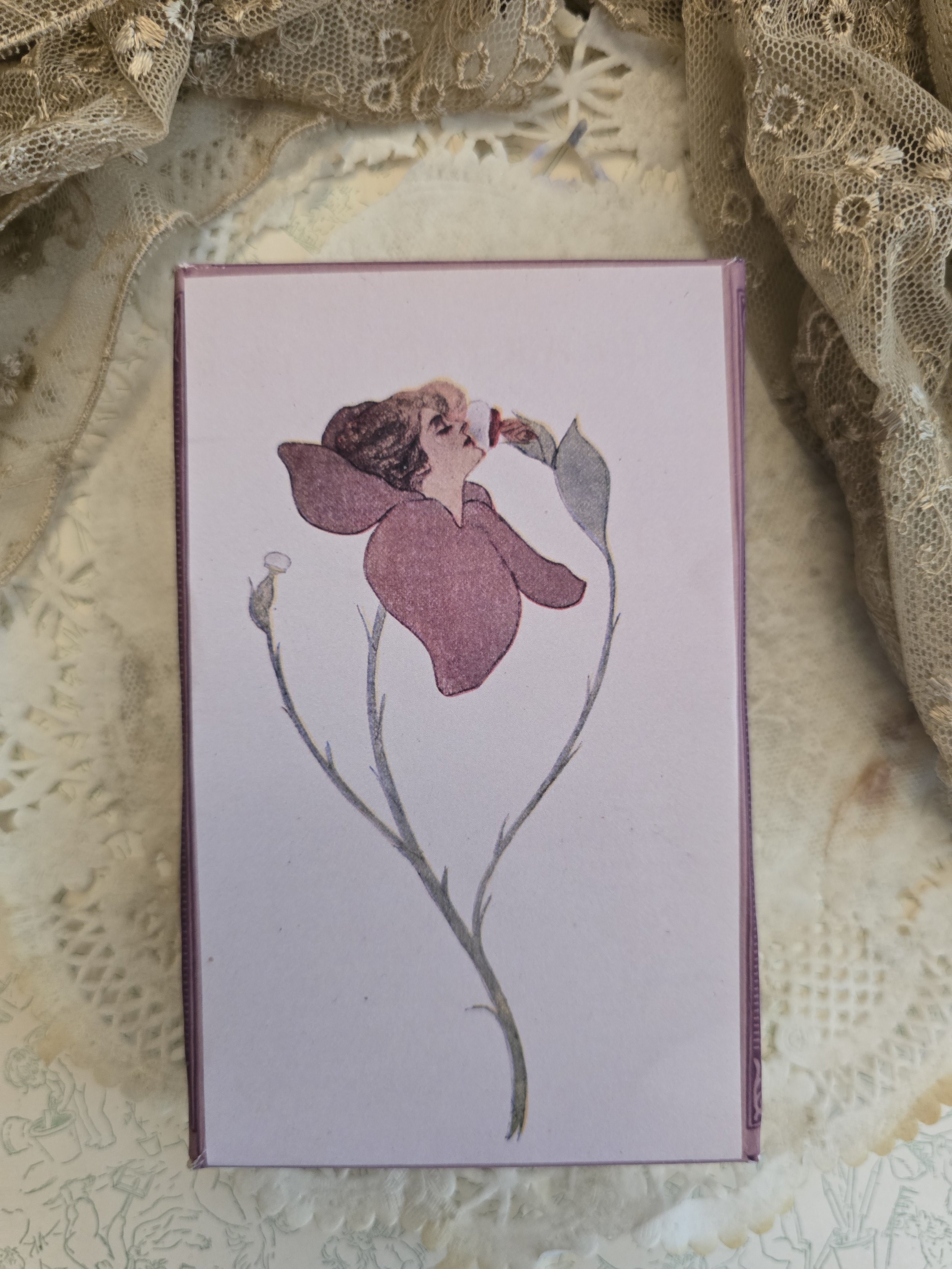 Close-up of The Puff Blossom Box showing a c.1912 antique illustration of a woman emerging from a mauve flower.