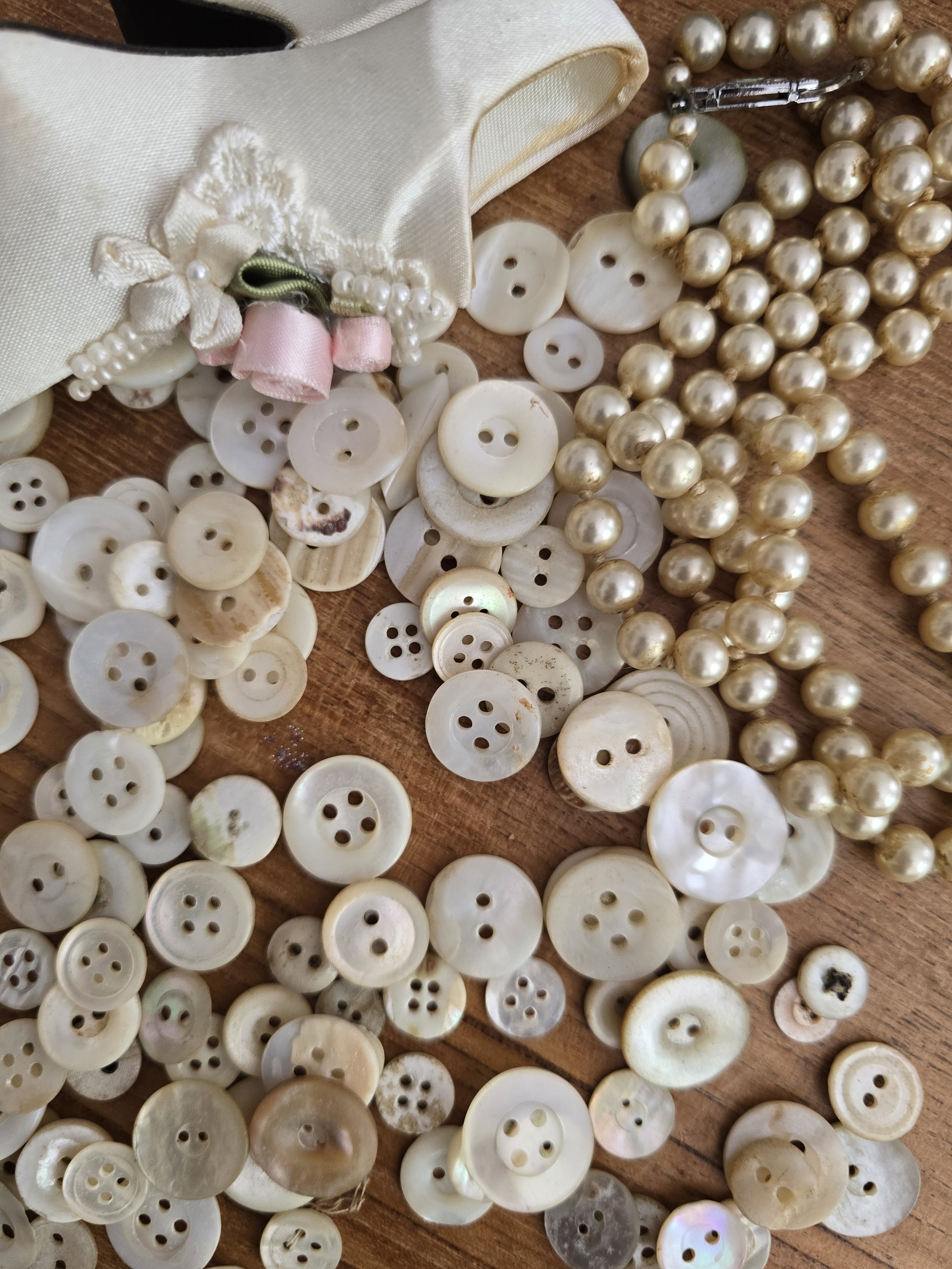 Collection of approximately 150 vintage mother of pearl buttons in assorted sizes and natural shell tones.