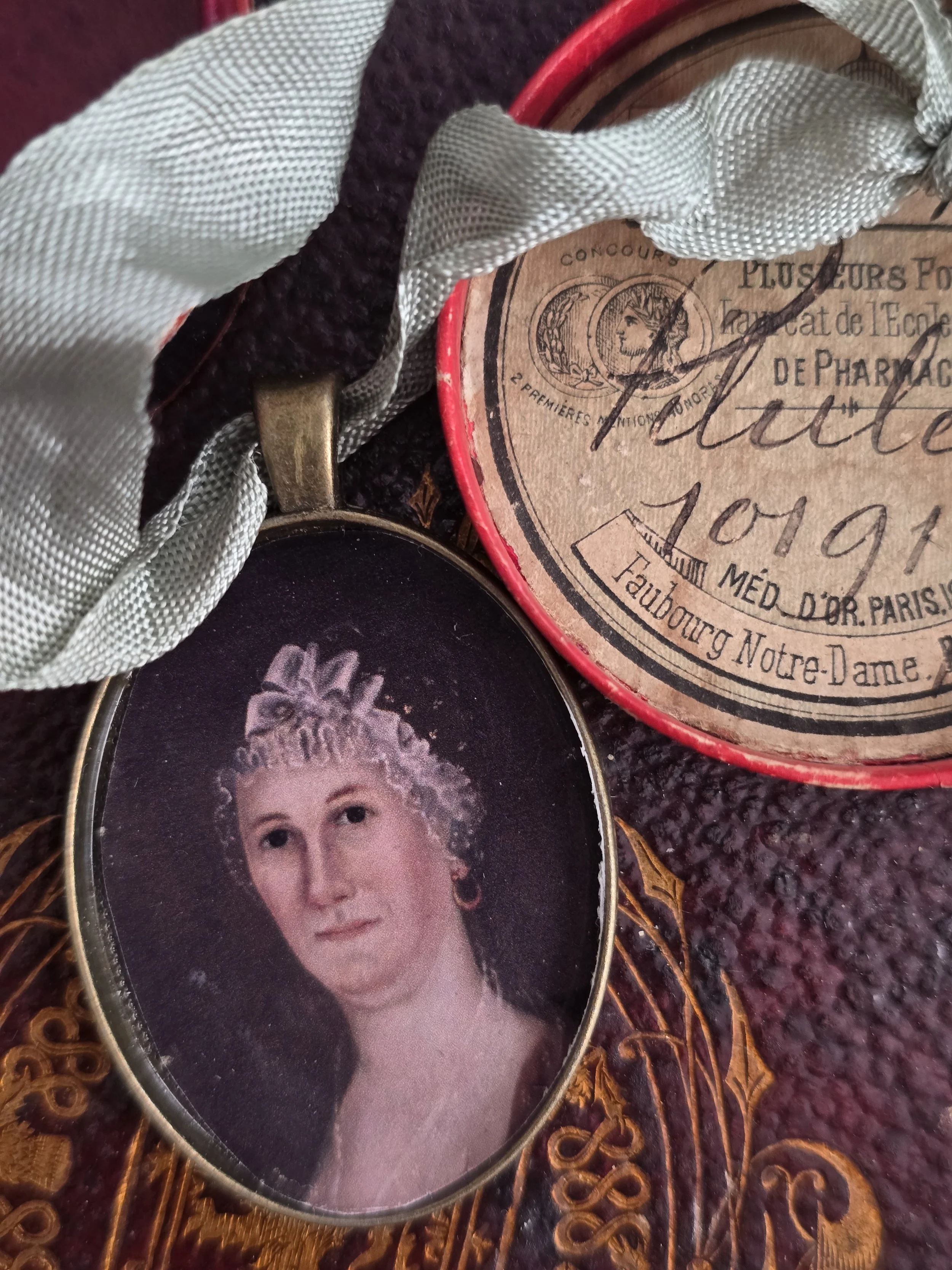 Close view of miniature portrait within an antique brass-tone oval setting.