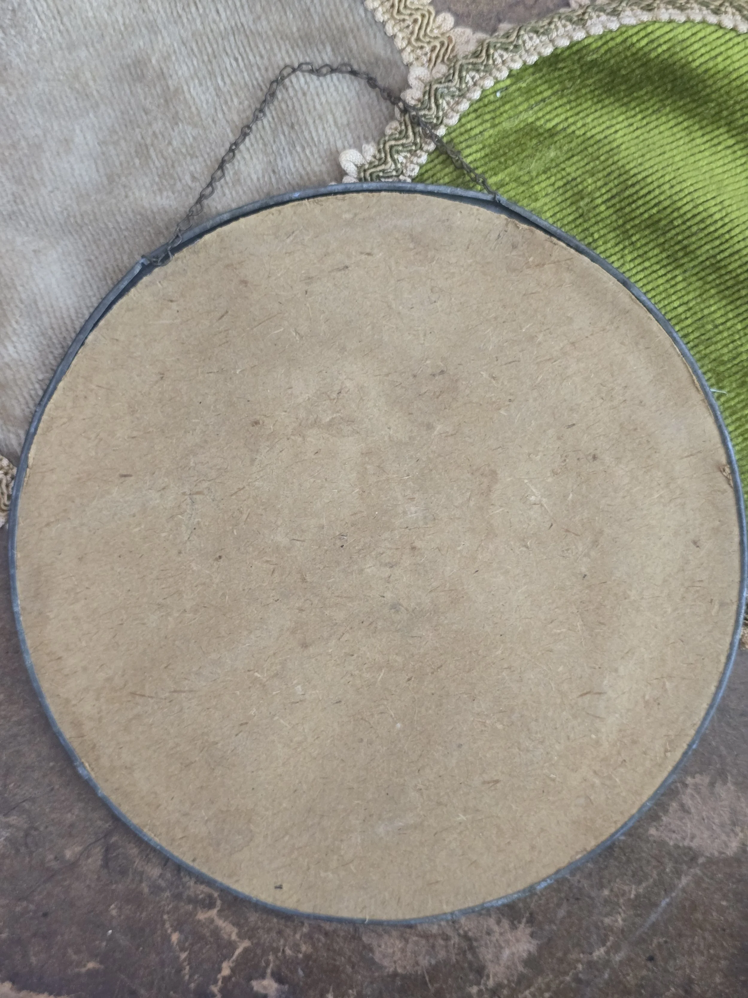 Circular wall plaque with original hanging chain and metal frame.
