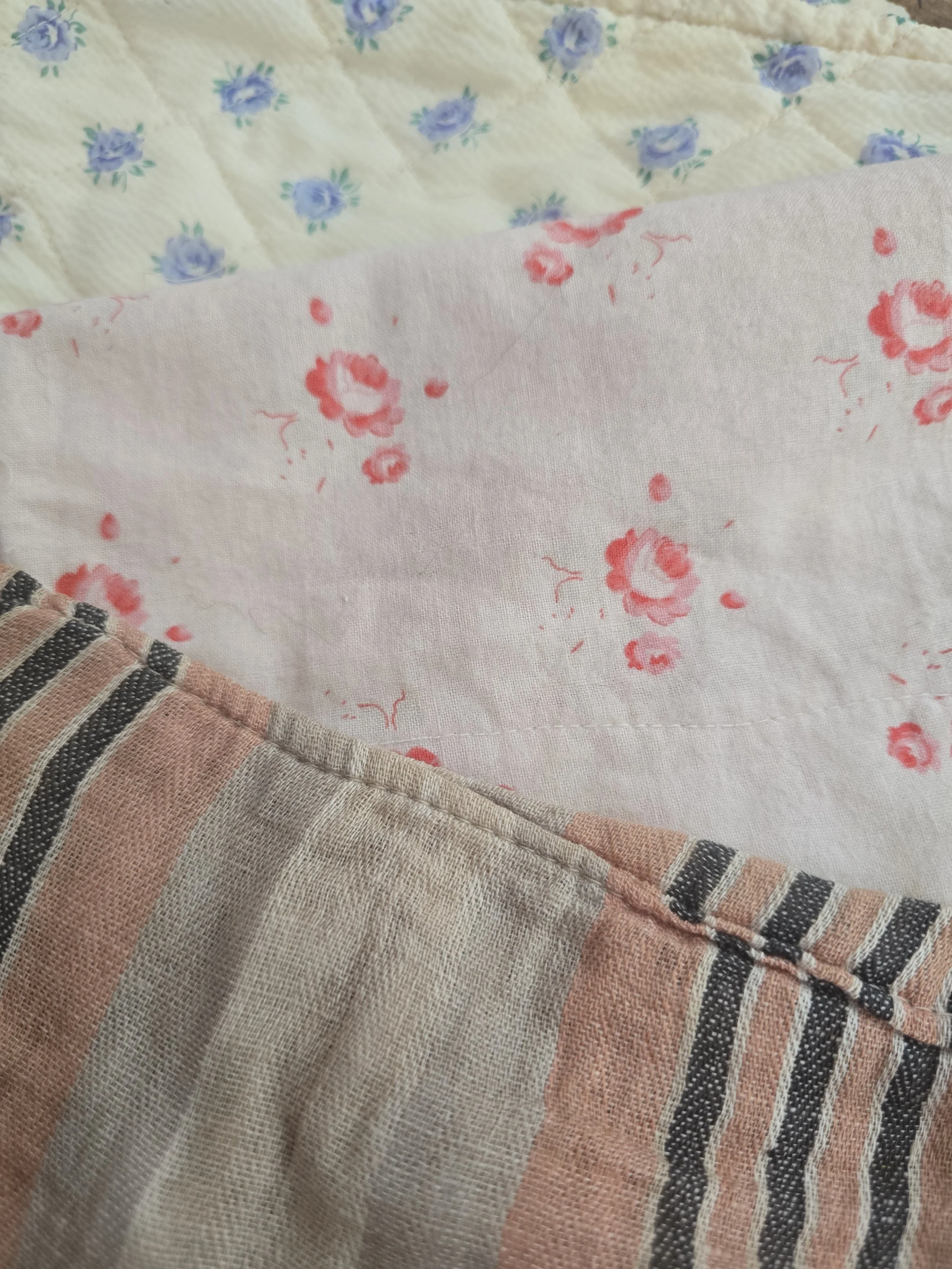 Antique doll's quilt with blue rosebud print on cream quilted cotton.