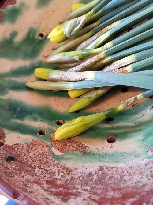 Close-up of antique ceramic berry strainer with green splatterware glaze and vintage patina