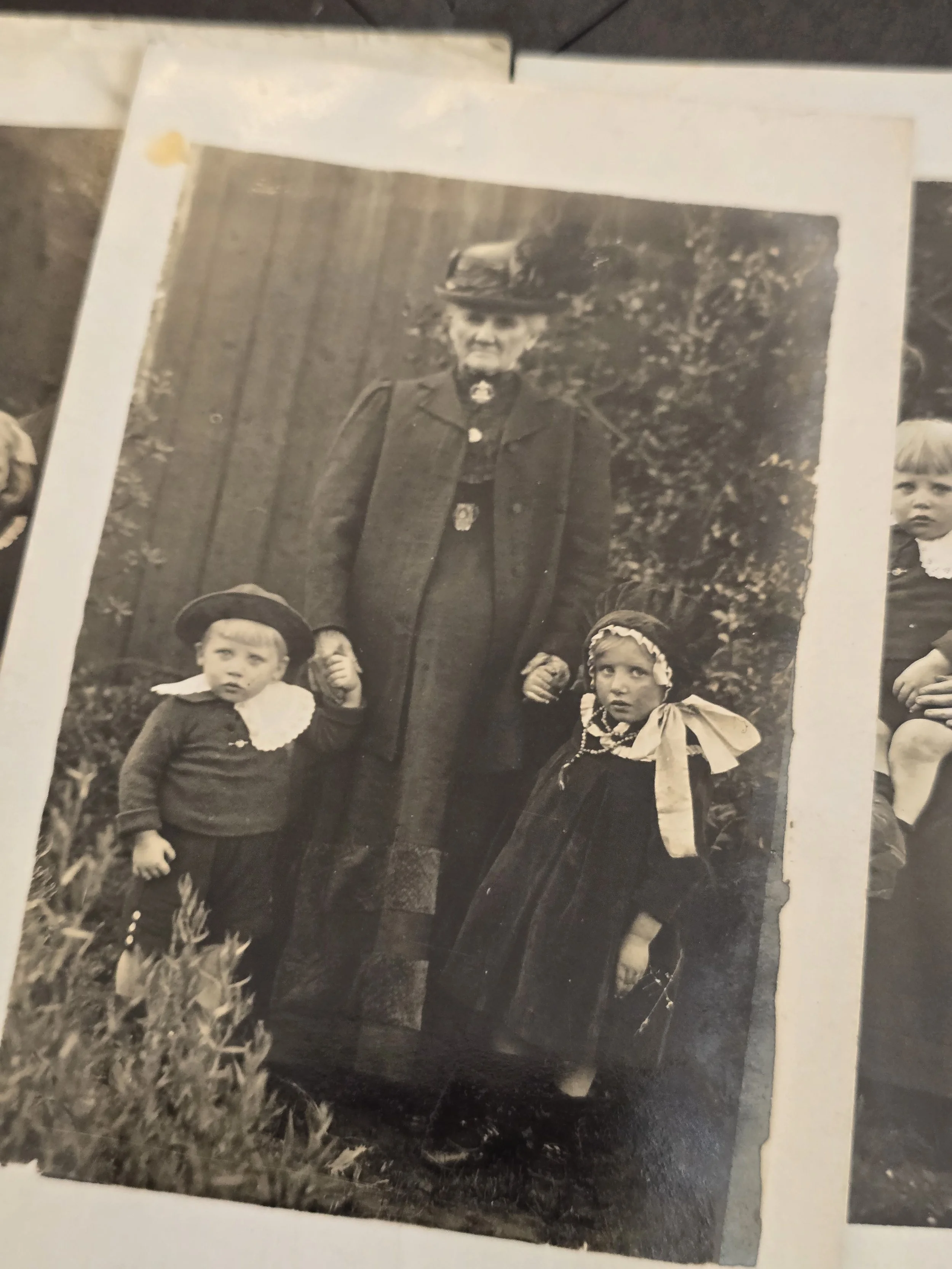 Detail of c.1910s family portrait showing children's large white collars, velvet dress and hair ribbons.