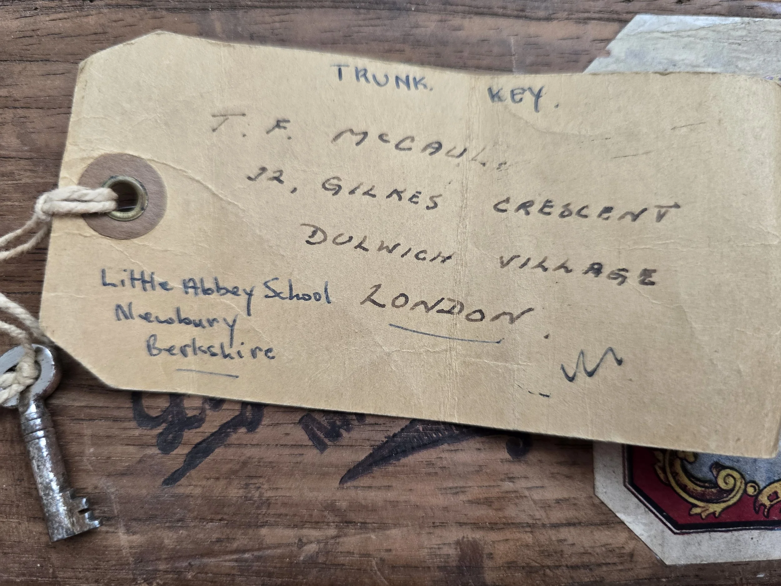 Vintage trunk key attached to original handwritten Little Abbey School luggage label