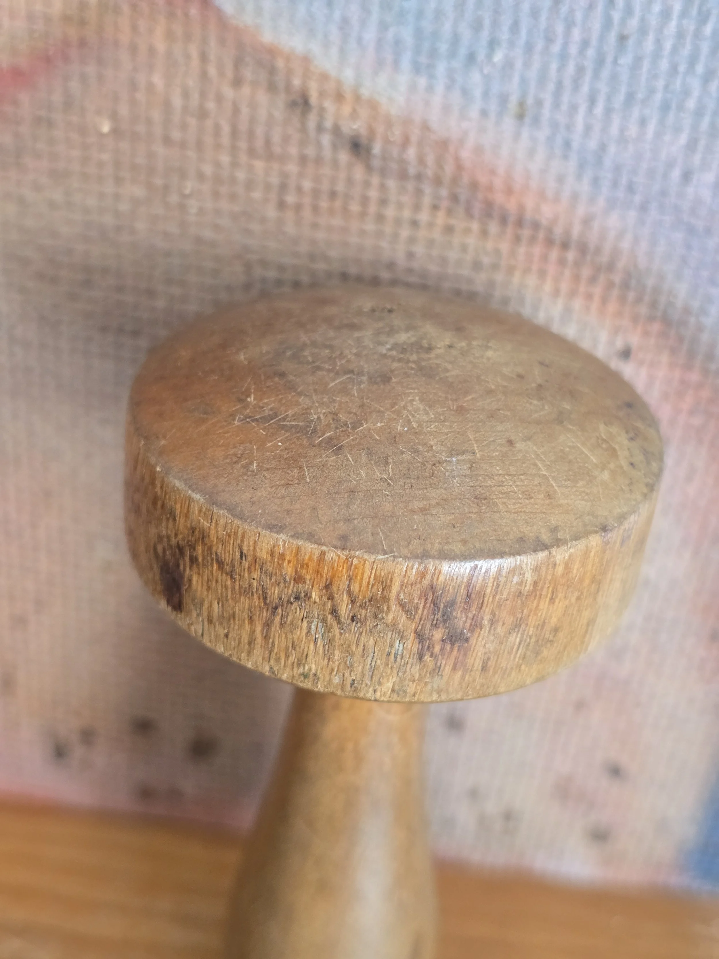 Close view of worn wooden darning mushroom showing years of use.