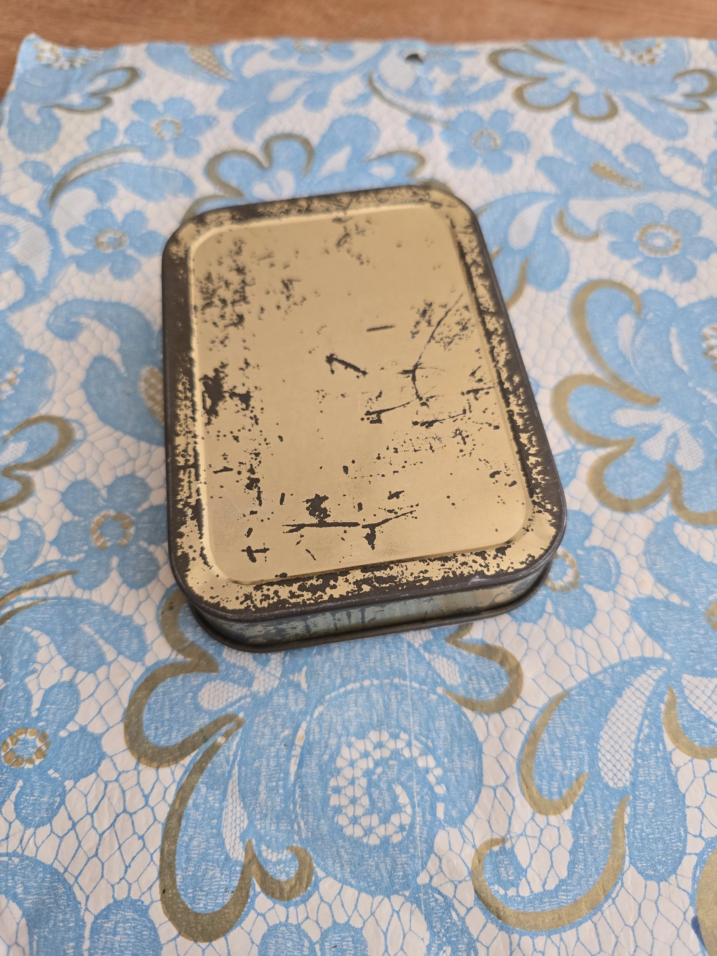 Decorative keepsake tin with romantic portrait and worn vintage patina.
