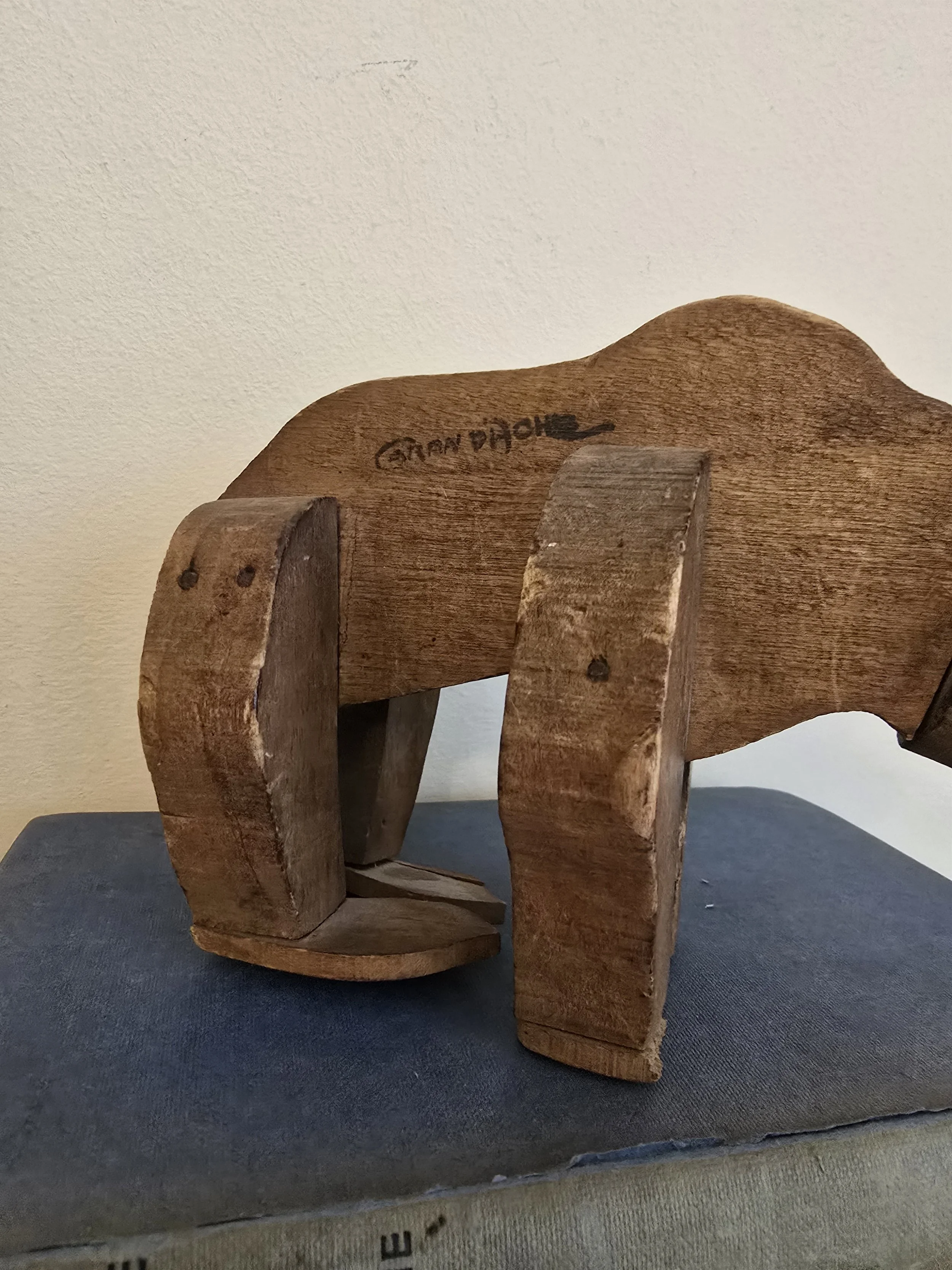 Side view of the antique wooden bear showing its sturdy articulated limbs and carved body