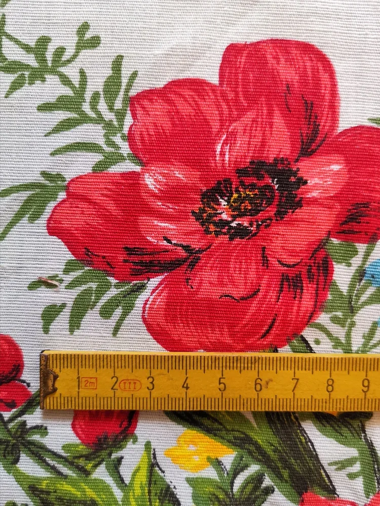 Large red poppy and yellow blossoms on vintage cotton floral fabric with textured surface.