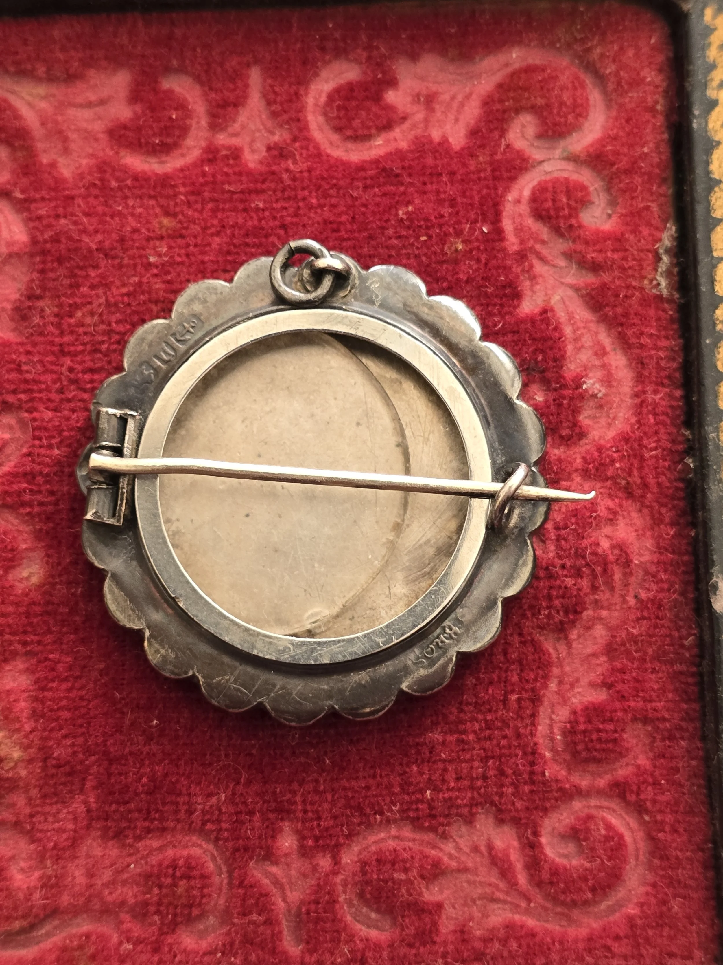 Detailed butterfly motif on antique silver brooch pendant.