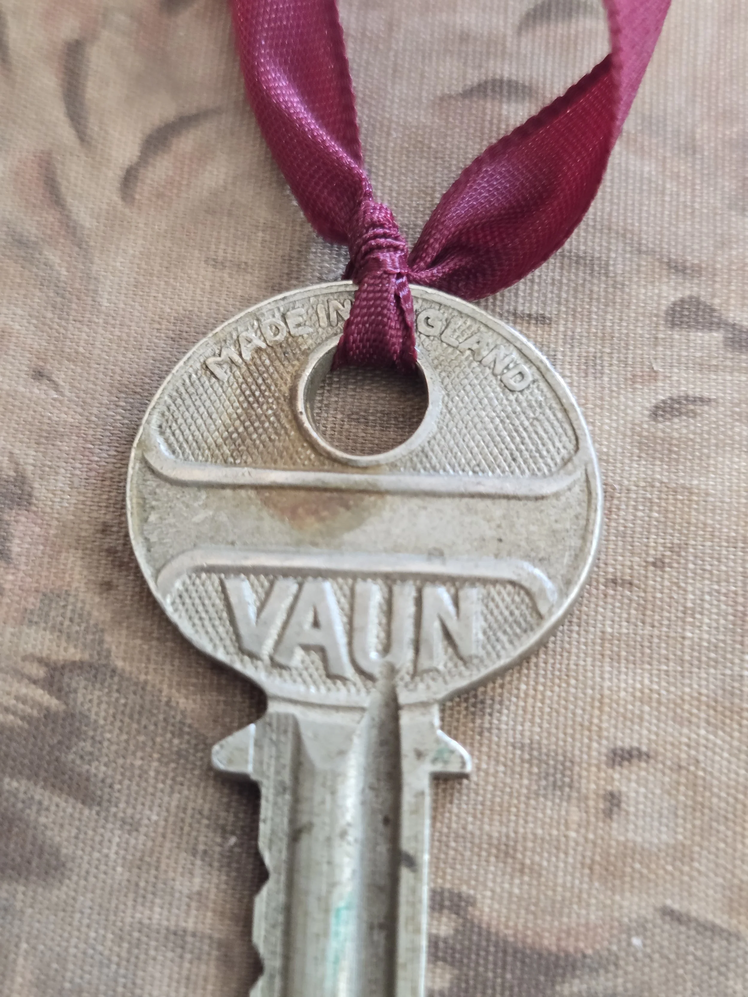 Close-up of antique Vaun key showing embossed lettering and aged metal patina.