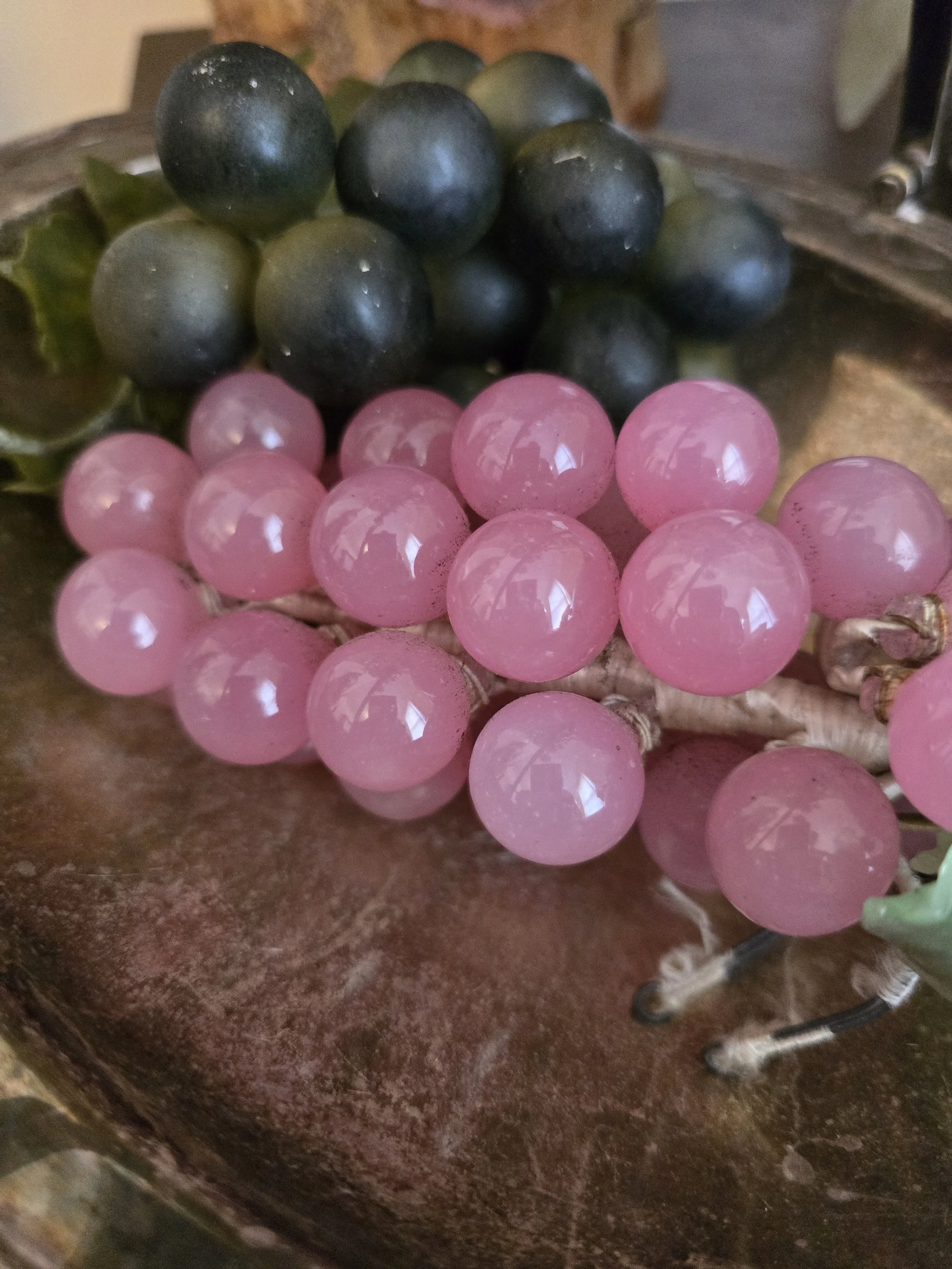 Vintage pink glass grape cluster with translucent glass grapes and green glass leaves.